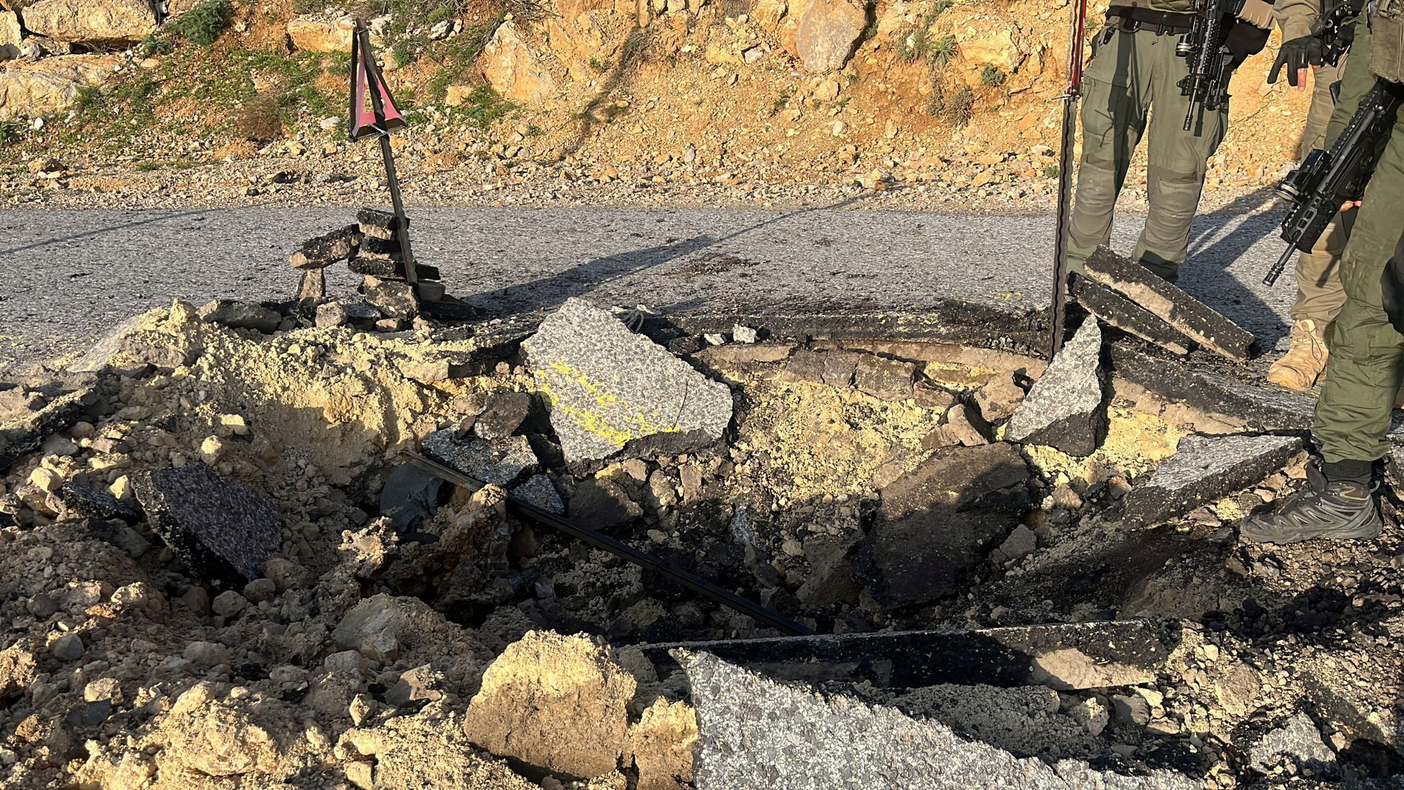 A view of a crater on a damaged road at a location given as Hermon area