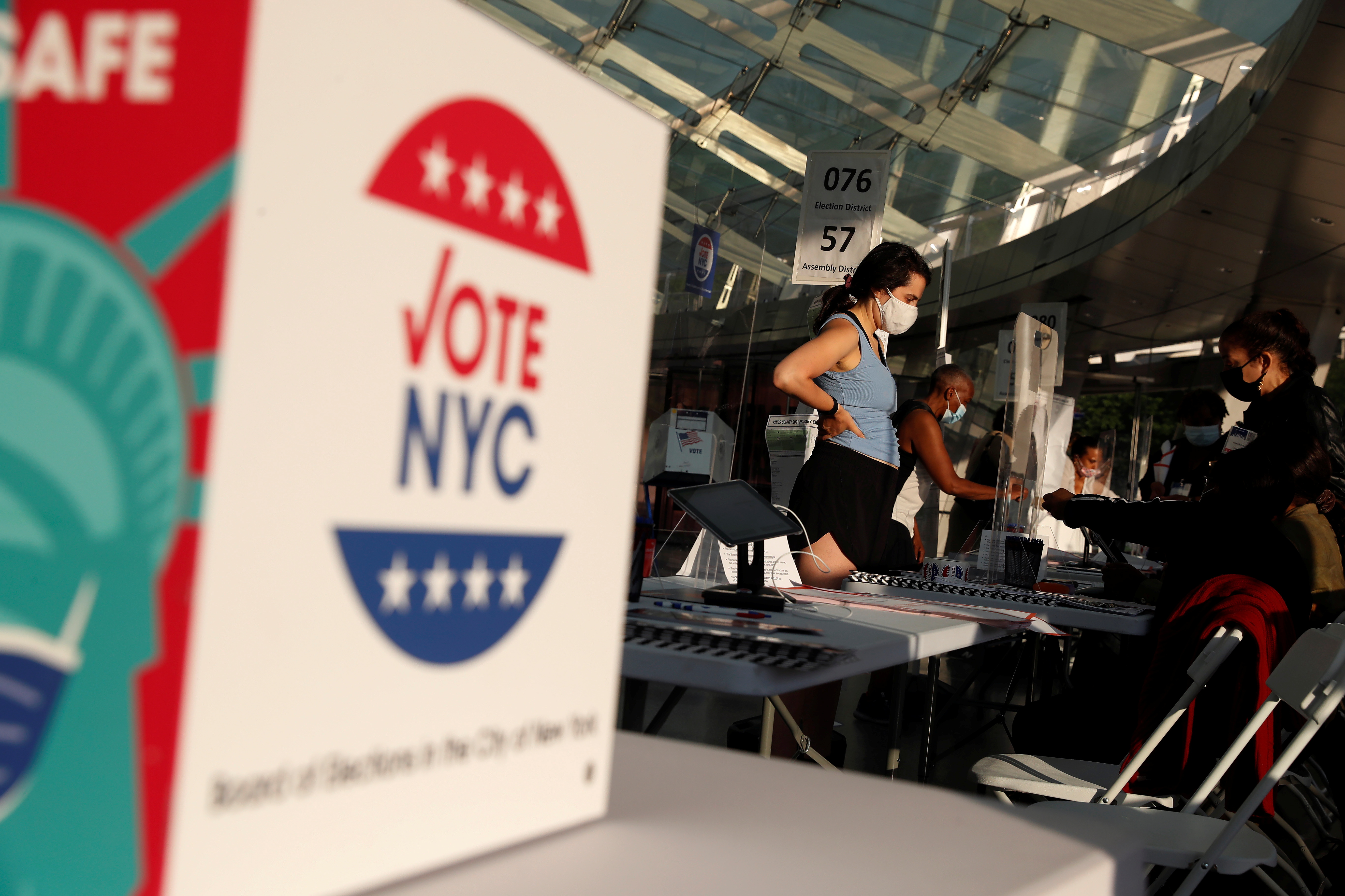 People wait to check in for voting in the New York Primary election at the Brooklyn Museum