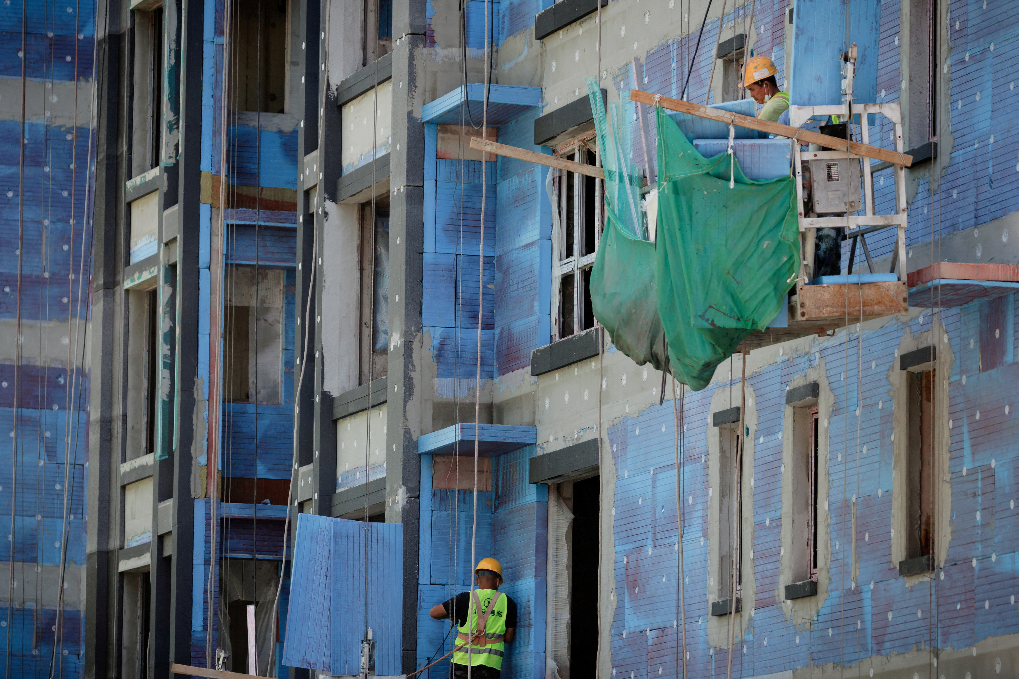 Men work at a construction site of apartment buildings in Beijing