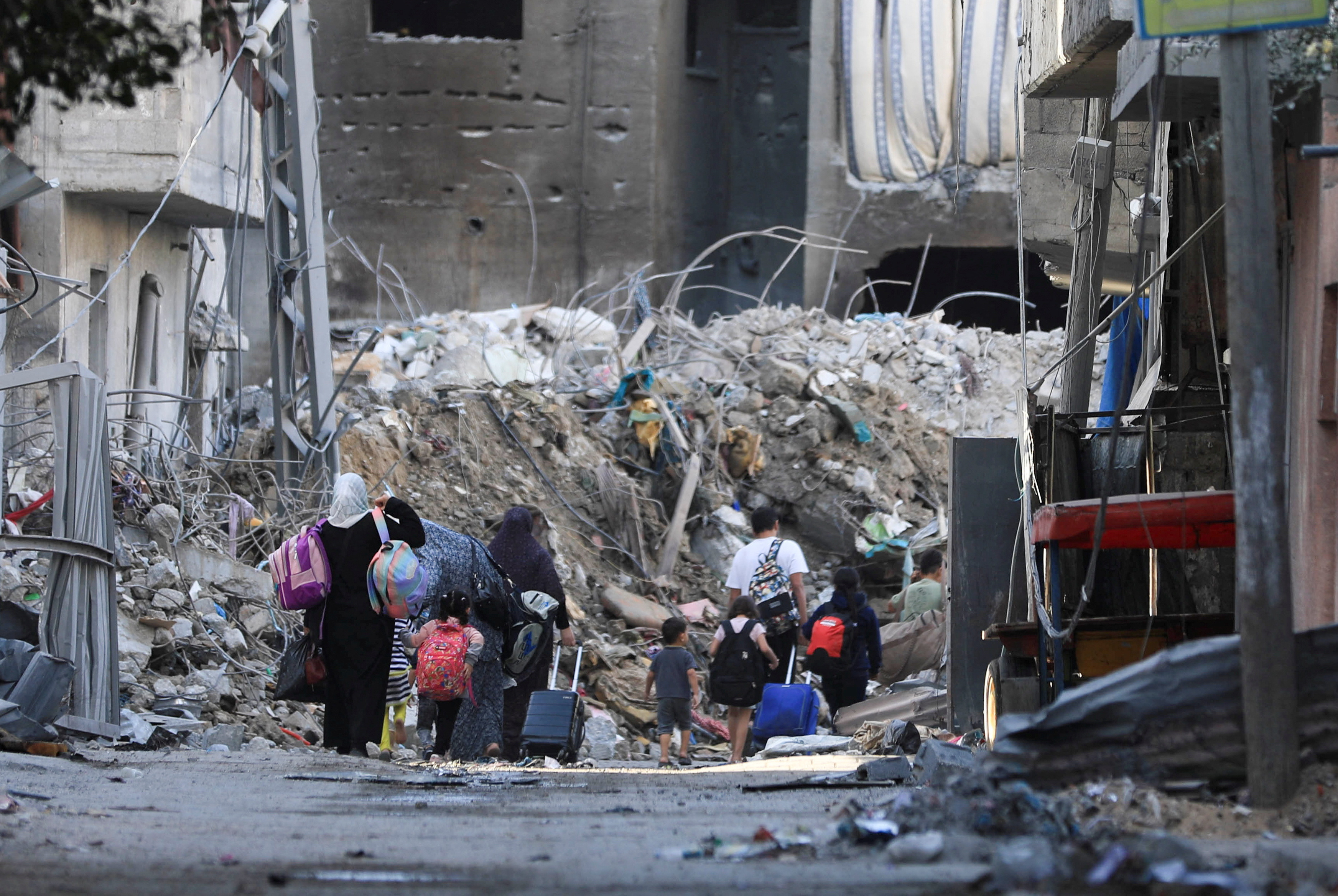 Palestinians carry their belongings as they flee their houses