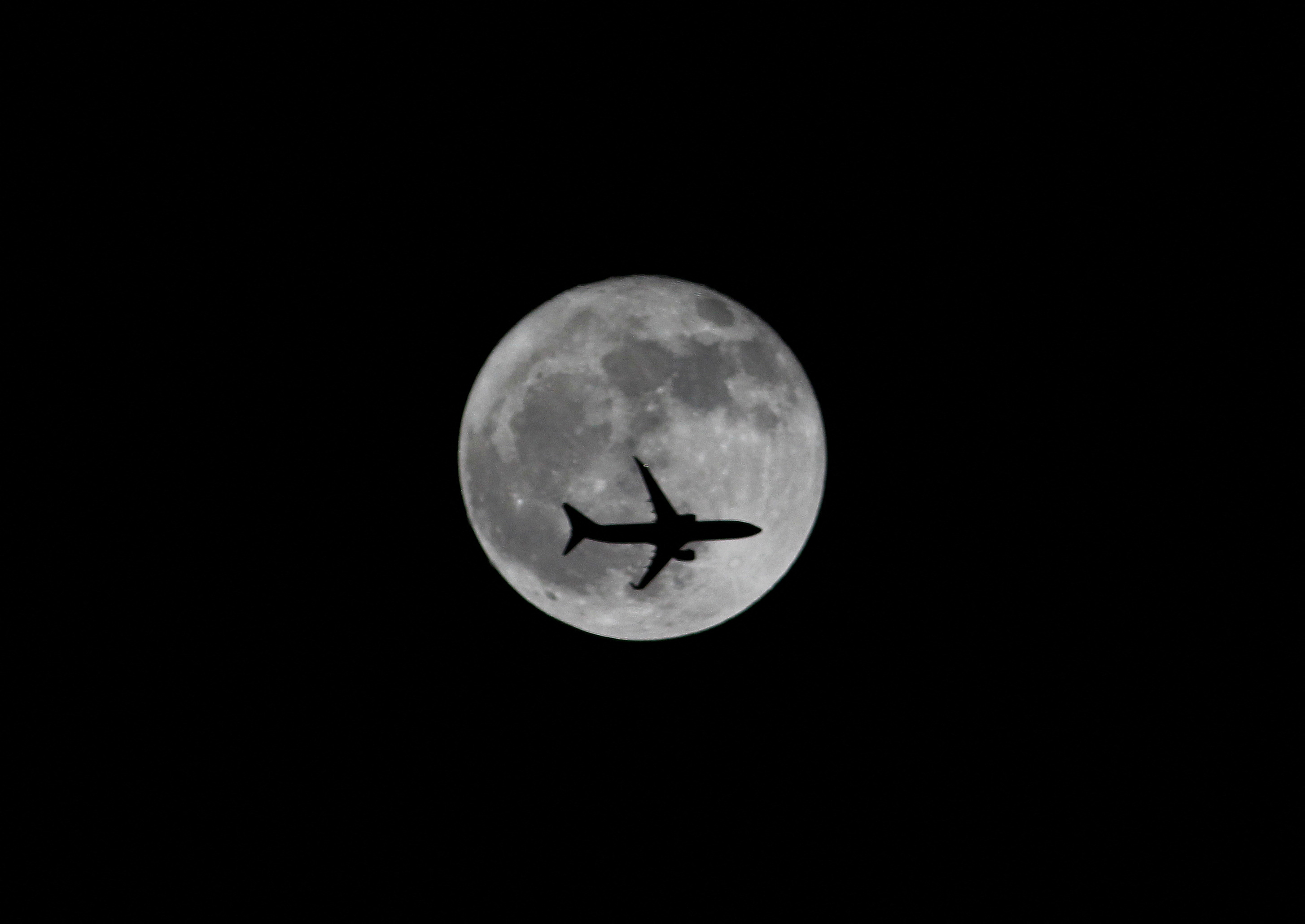 Passenger plane passes the moon as it comes into land at the international airport in Chennai