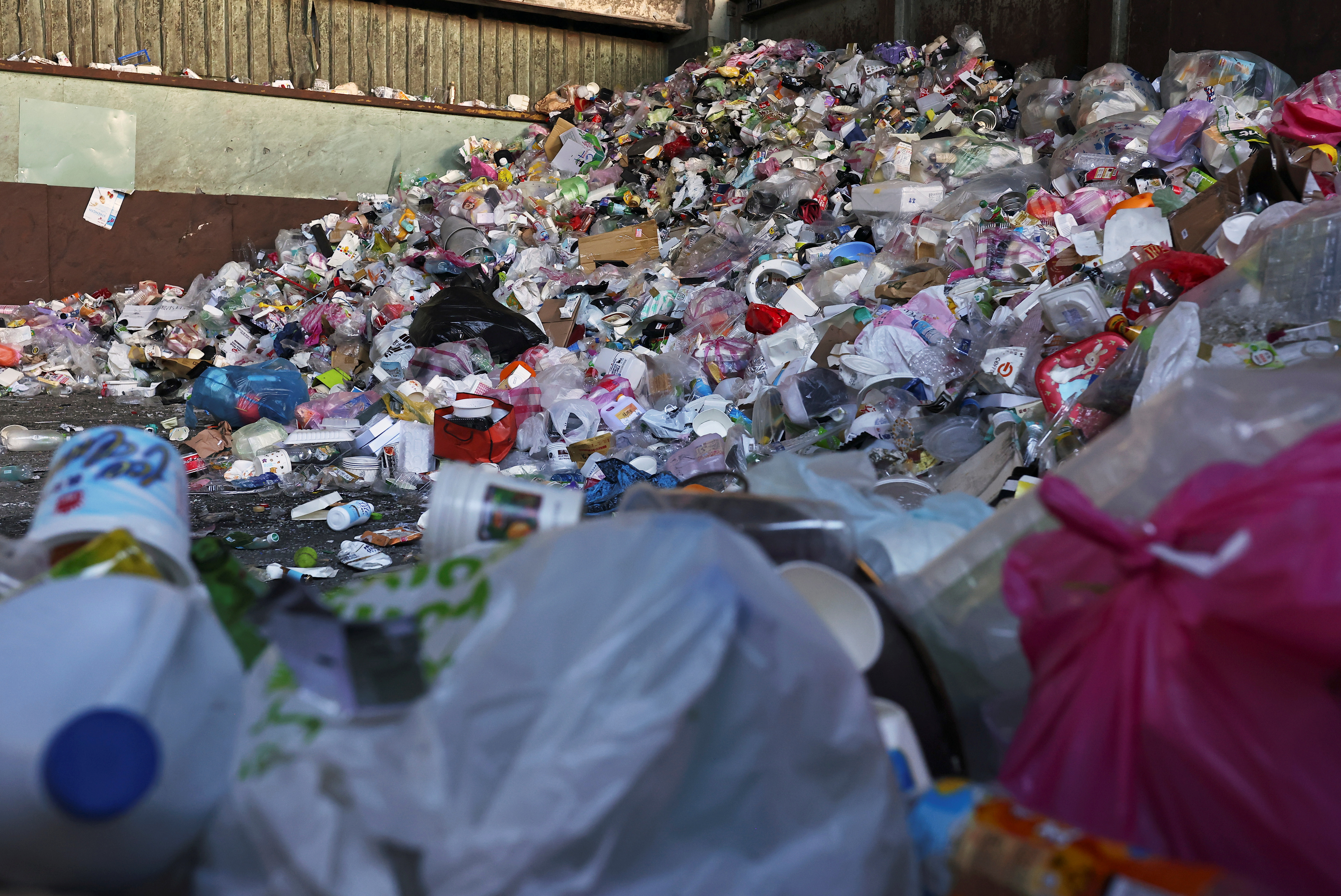 Plastic containers are seen amid other trash at a waste collection plant in Taipei