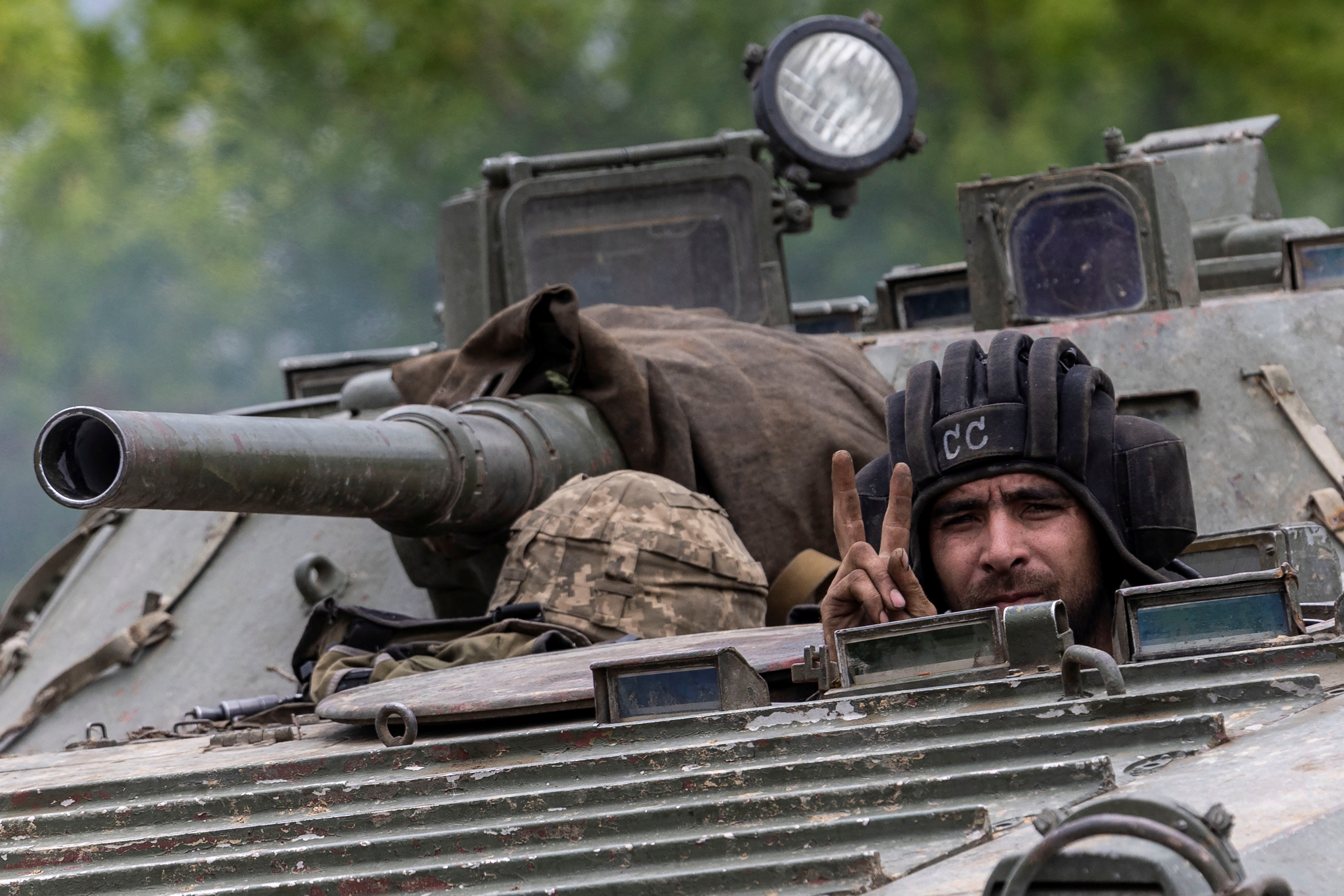 An Ukrainian service member rides on top of a military vehicle, amid Russia's invasion of Ukraine, on the road from Bakhmut to Kostyantynivka, in the Donetsk region, Ukraine