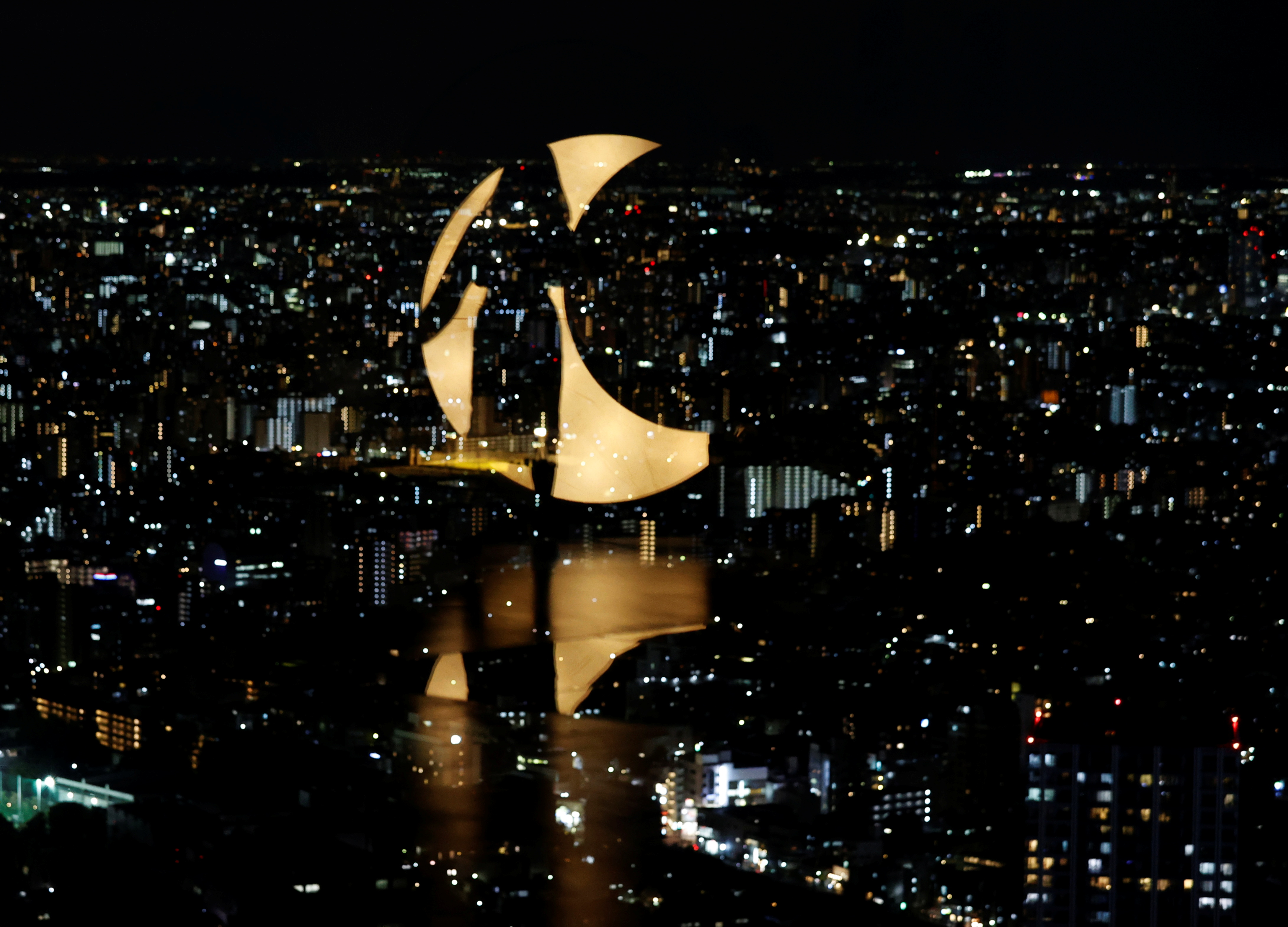 A visitor and moon-shaped light are reflected on a window at Sunshine City's Observatory after COVID-19 controls were eased, in Tokyo, Japan, October 15, 2021. REUTERS/Kim Kyung-Hoon