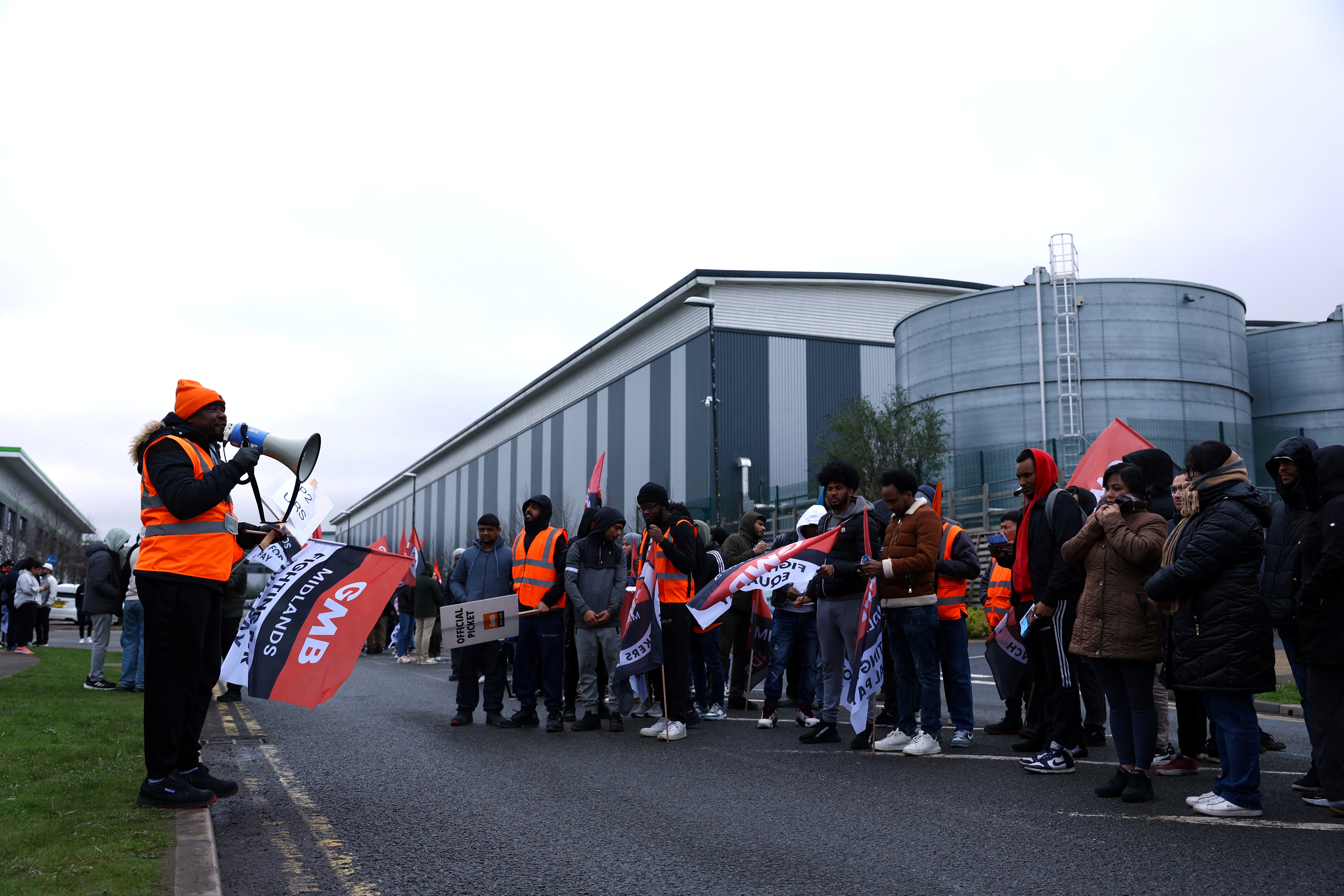Protestors hold banners during industrial action outside the Amazon warehouse