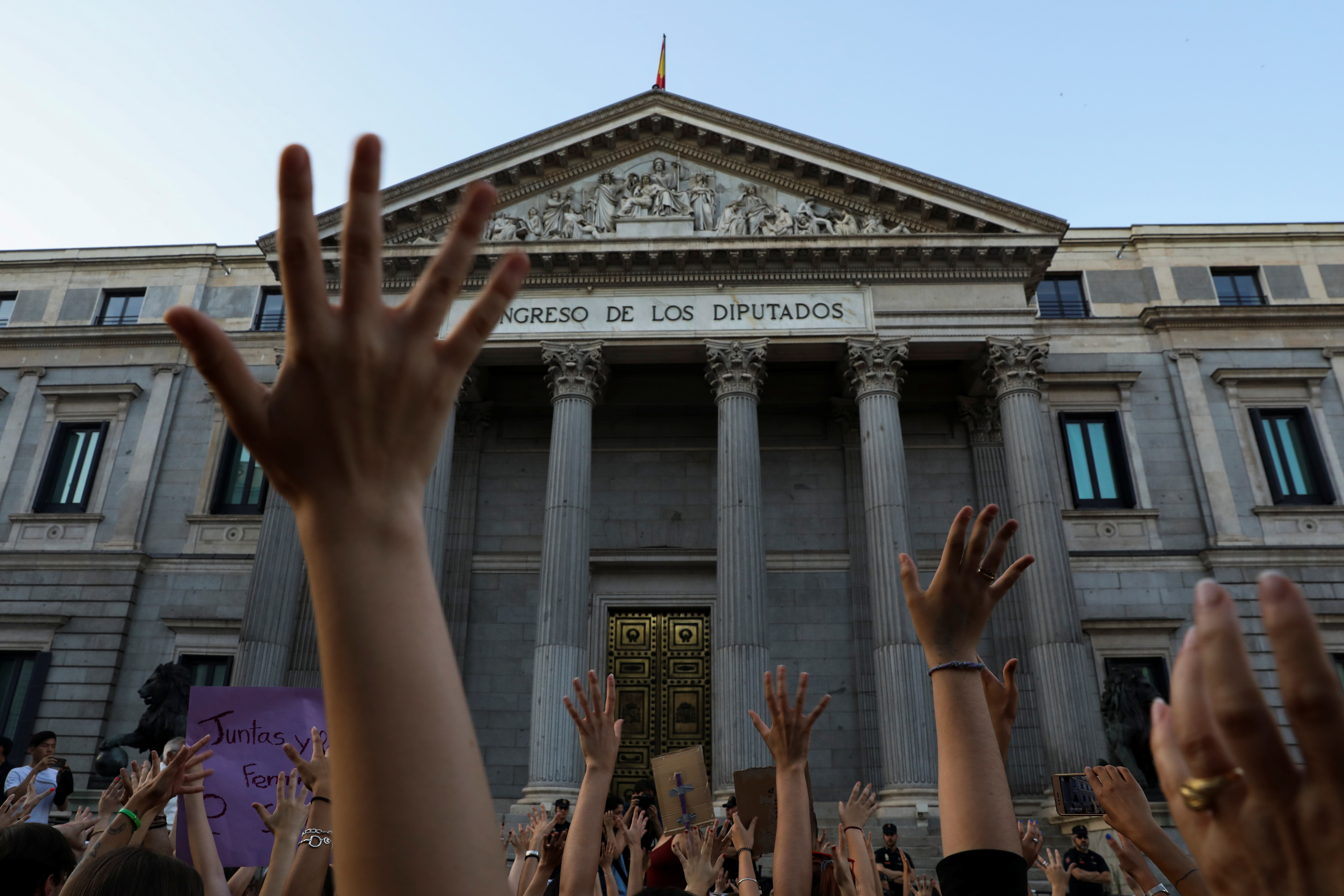 Protesters do a sit down in front of the Spanish Parliament during a demonstration against the release on bail of five men known as the "Wolf Pack" cleared of a gang rape of a teenager and convicted of a lesser crime of sexual abuse in Madrid