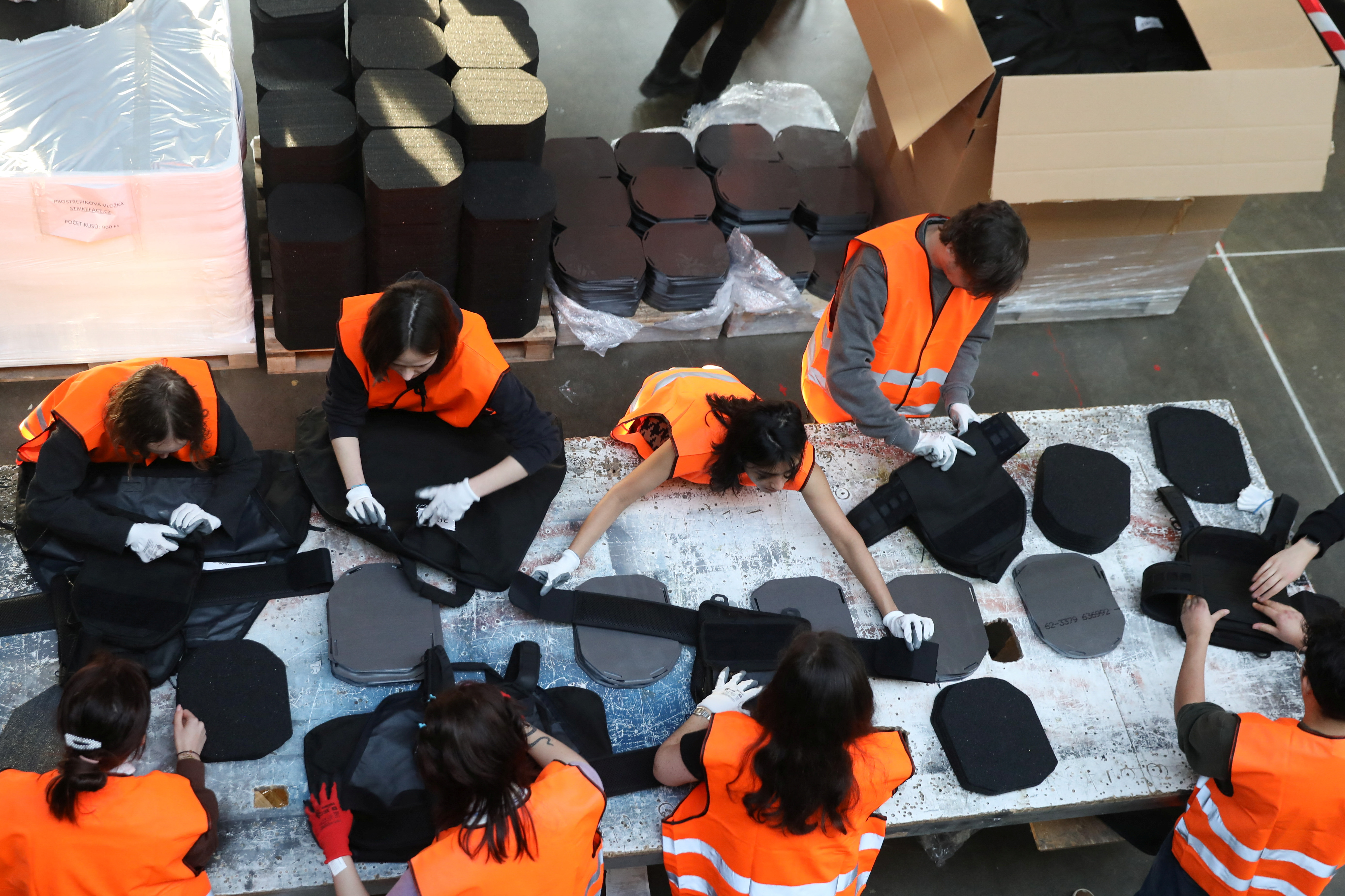 Volunteers assemble flak jackets in a warehouse in Prague