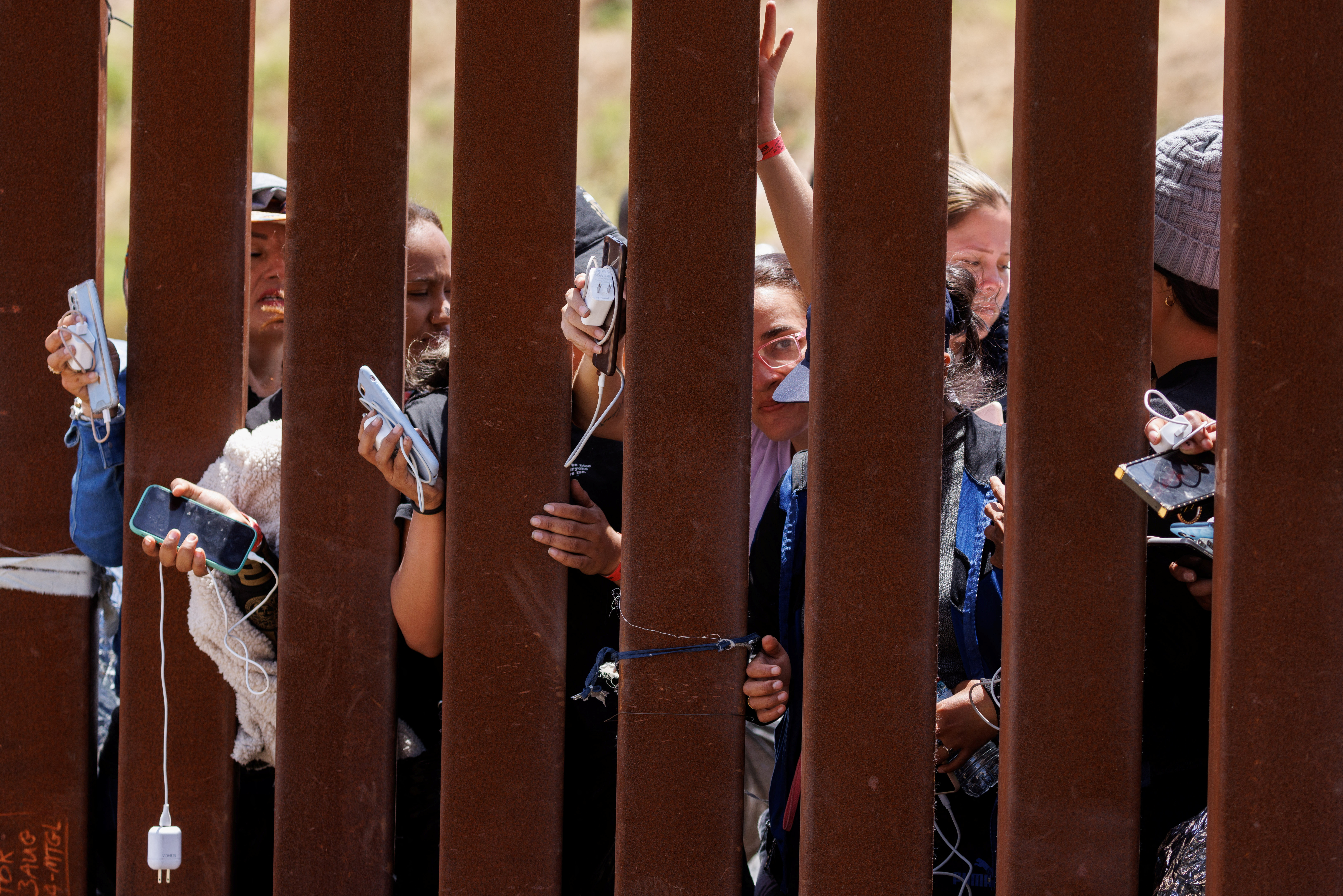 Migrants gather along the U.S. Mexico border near San Diego before the lifting of Tile 42