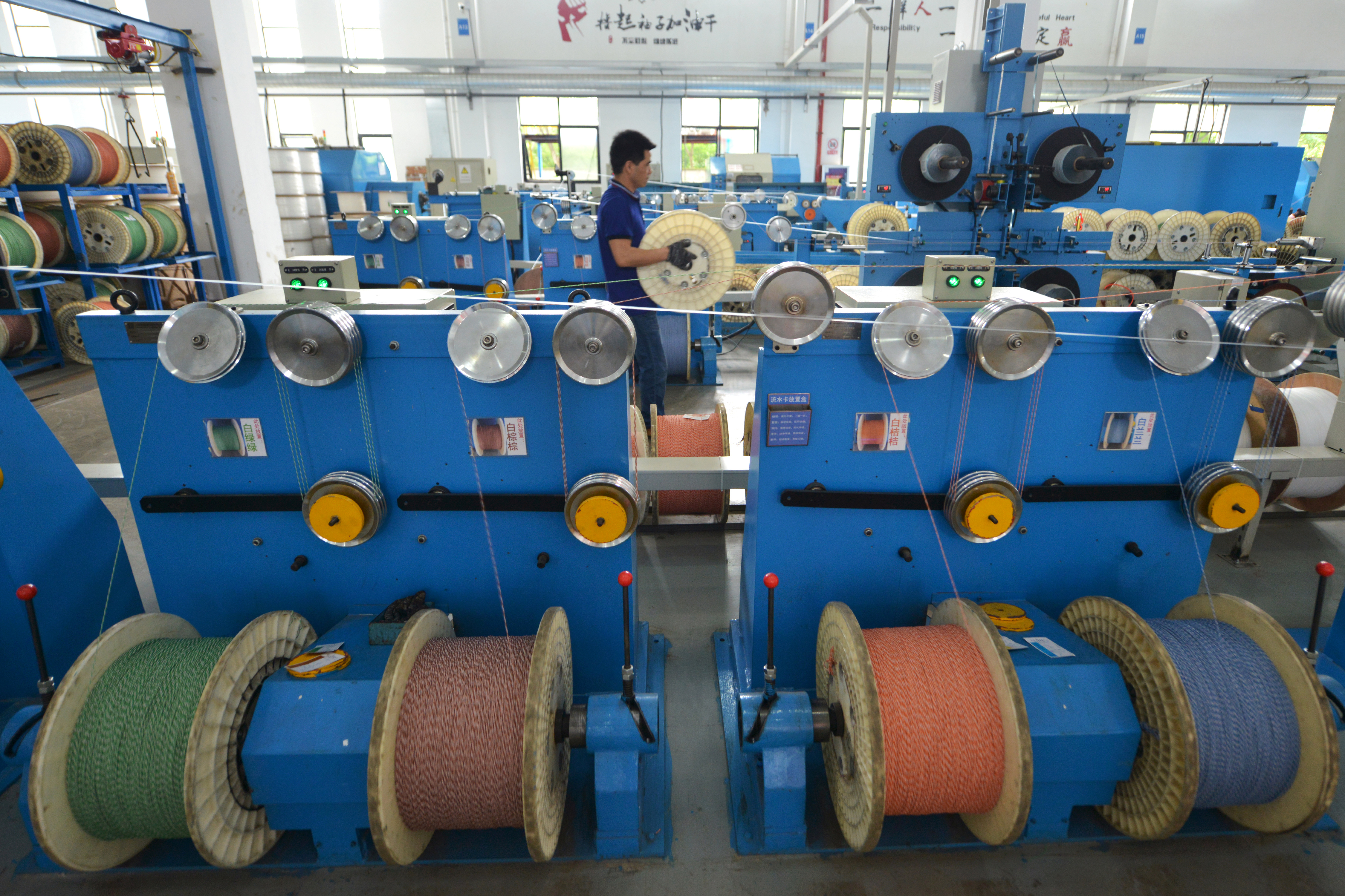 Employee works at a factory of the Zhejiang Headway Communication Equipment Co in Huzhou