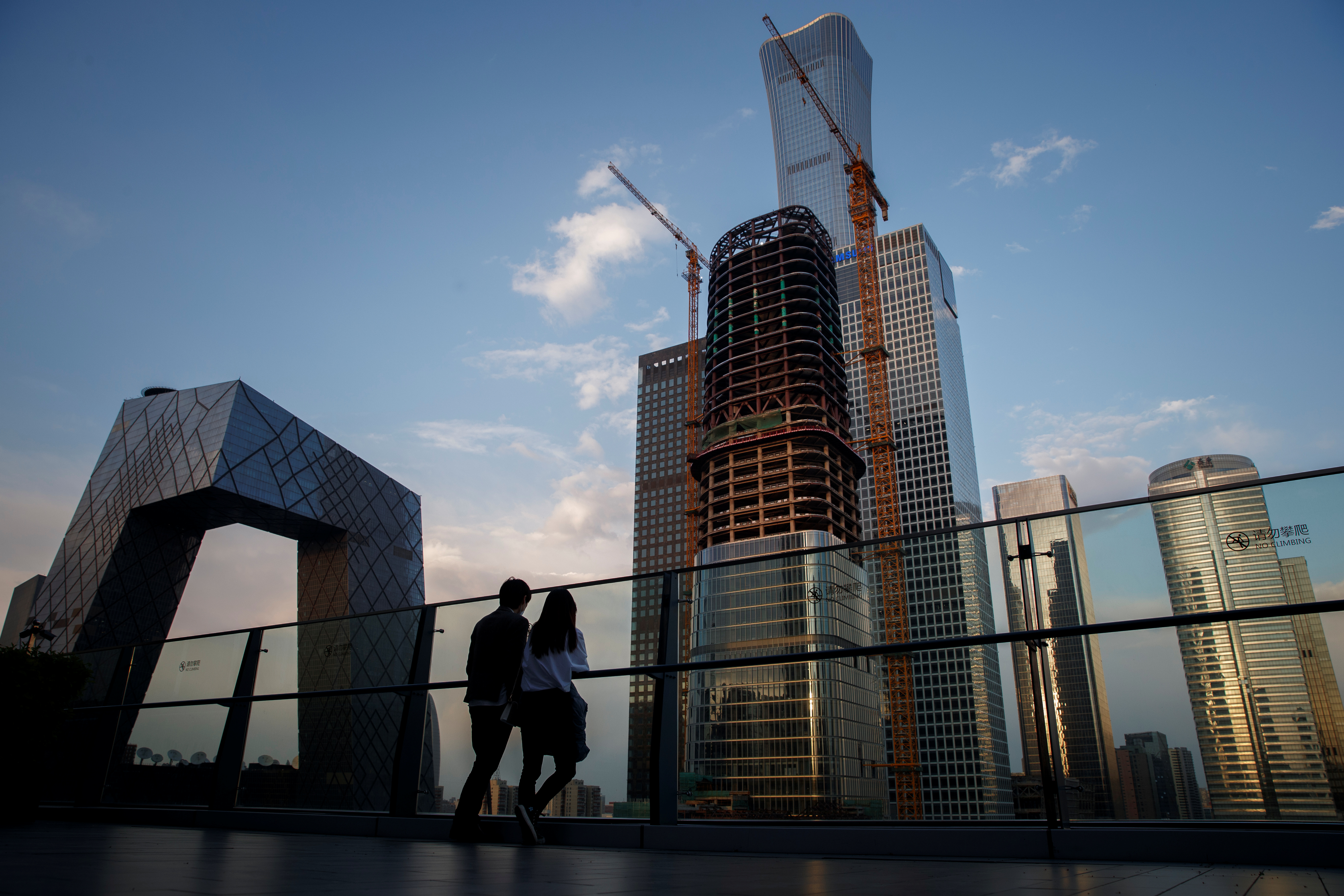 People look at the skyline of the Central Business District in Beijing