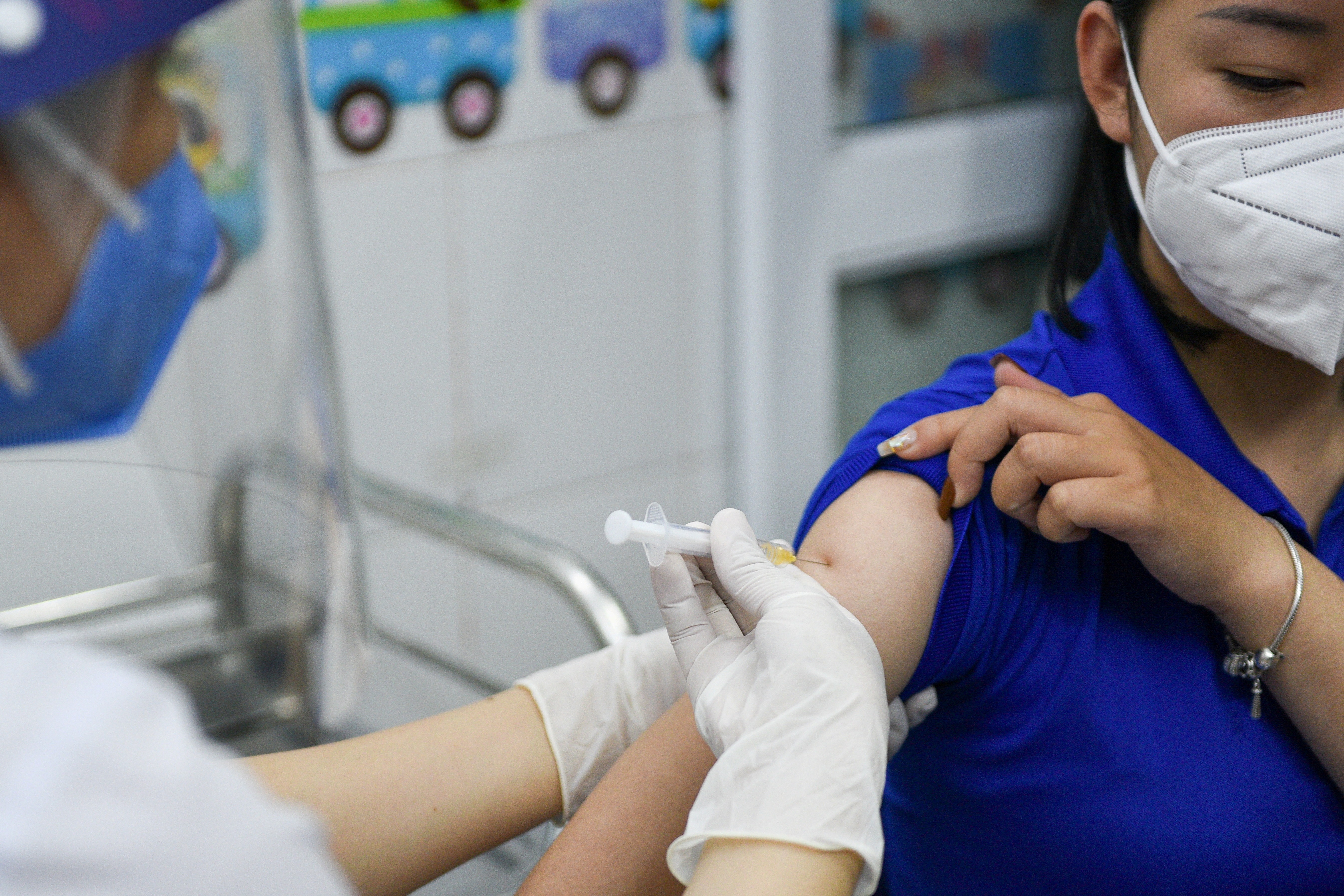 FILE PHOTO: A woman receives a vaccine as Vietnam starts its official rollout of AstraZeneca's COVID-19 vaccine, in Hai Duong