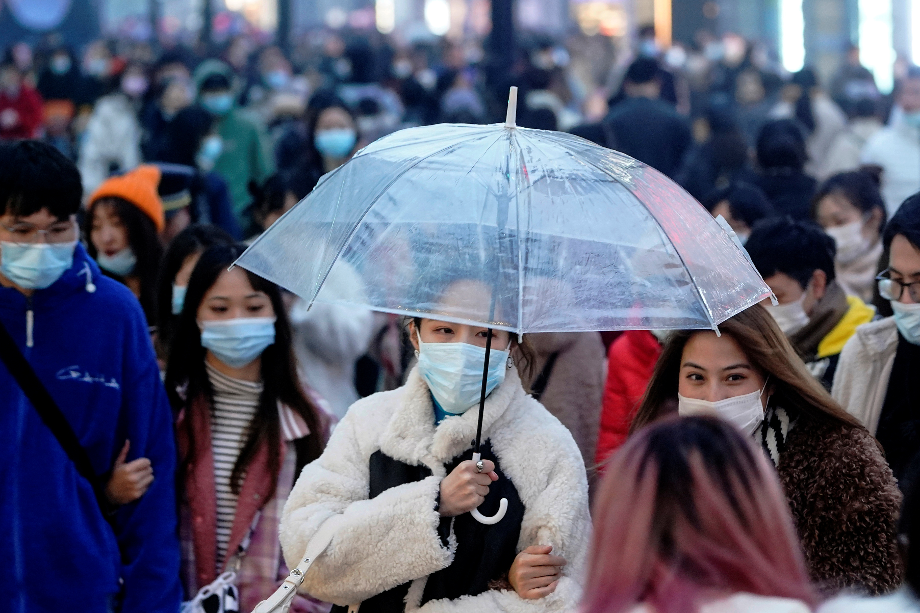 People wearing face masks are seen at a main shopping area almost a year after the global outbreak of the coronavirus disease (COVID-19) in Wuhan