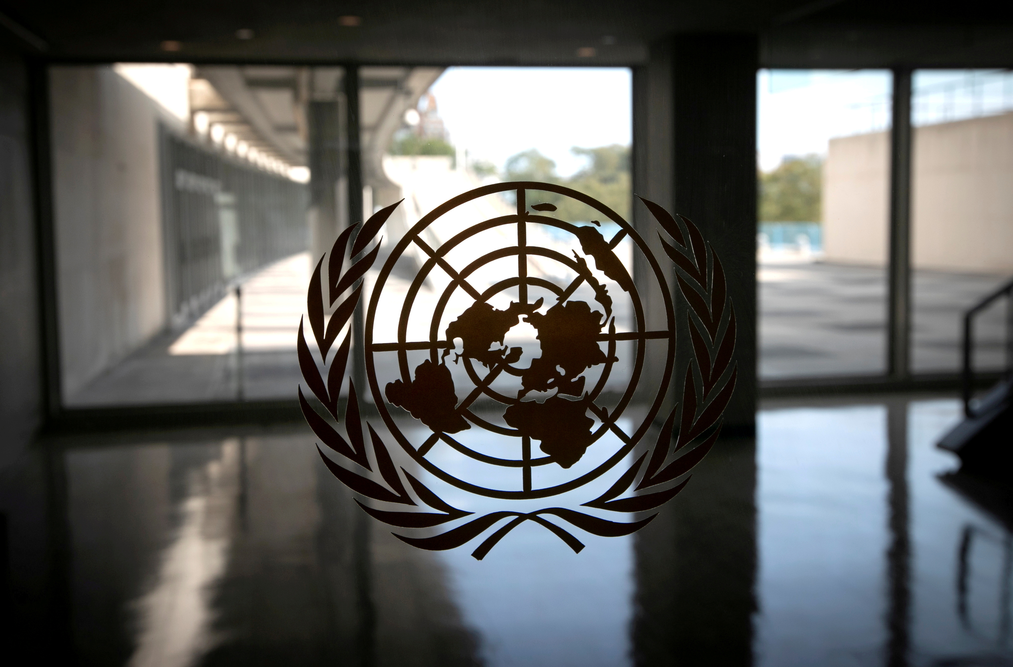 The United Nations logo is seen on a window in an empty hallway at United Nations headquarters