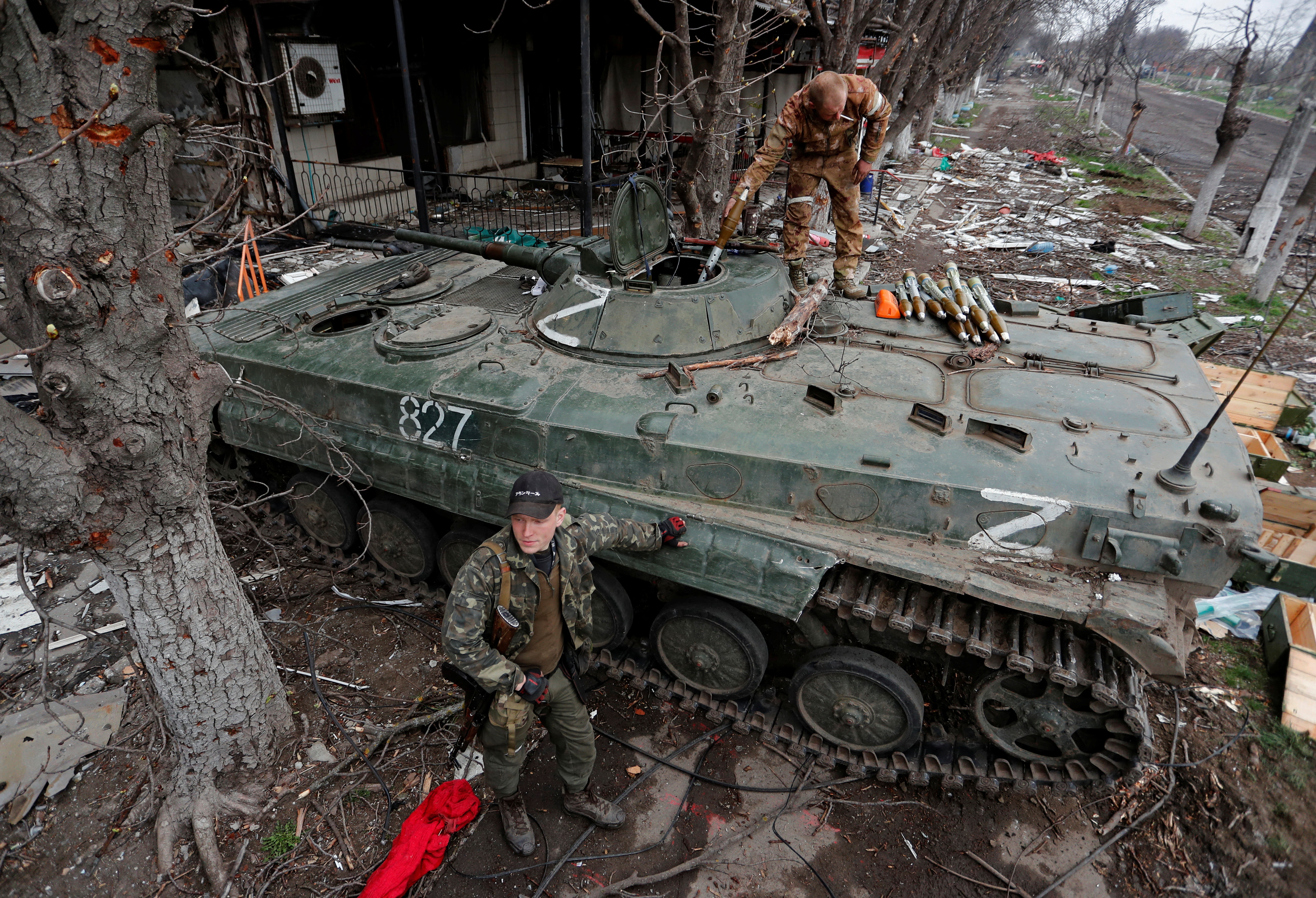 Service members of pro-Russian troops load ammunition into armoured vehicles during fighting in Mariupol