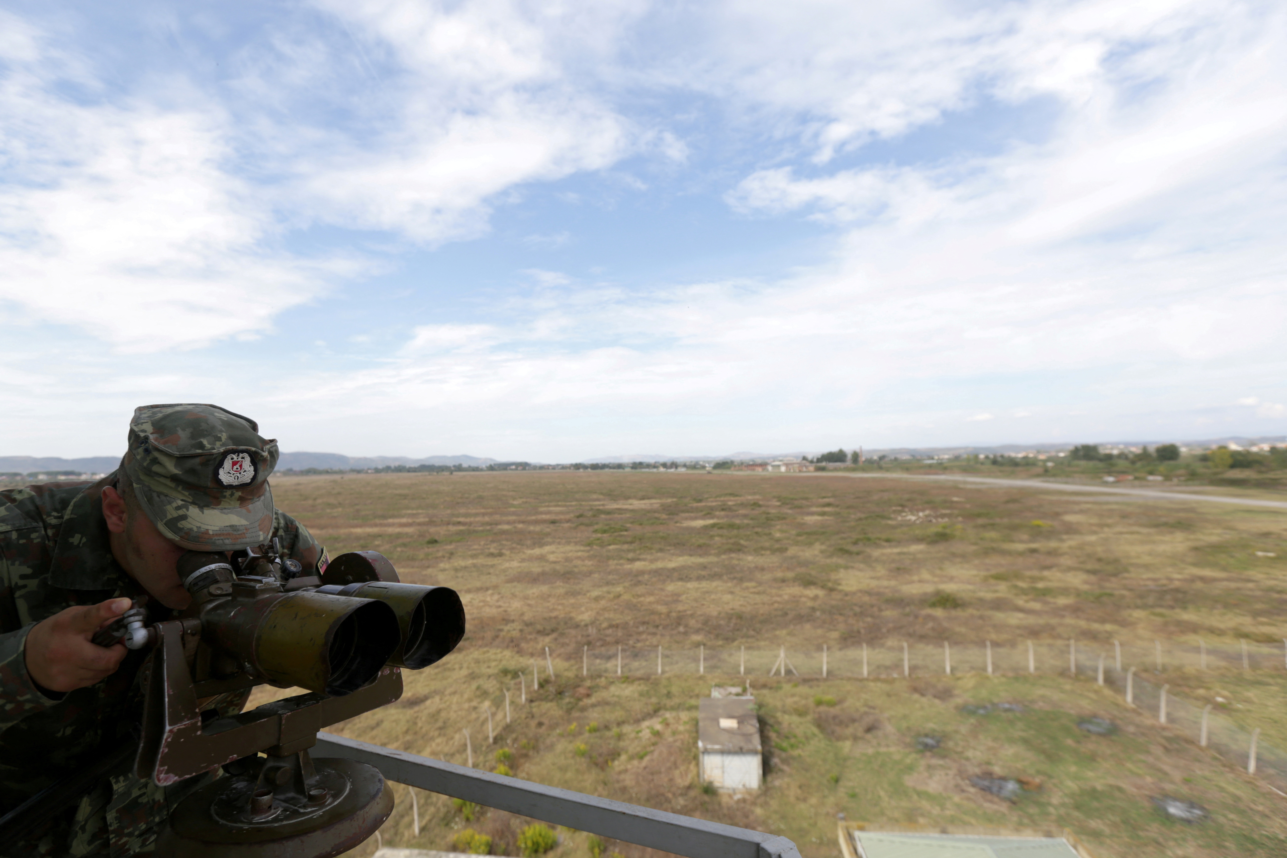 An Albanian Military Force member use uses binoculars in Kucova Air Base in Kucova