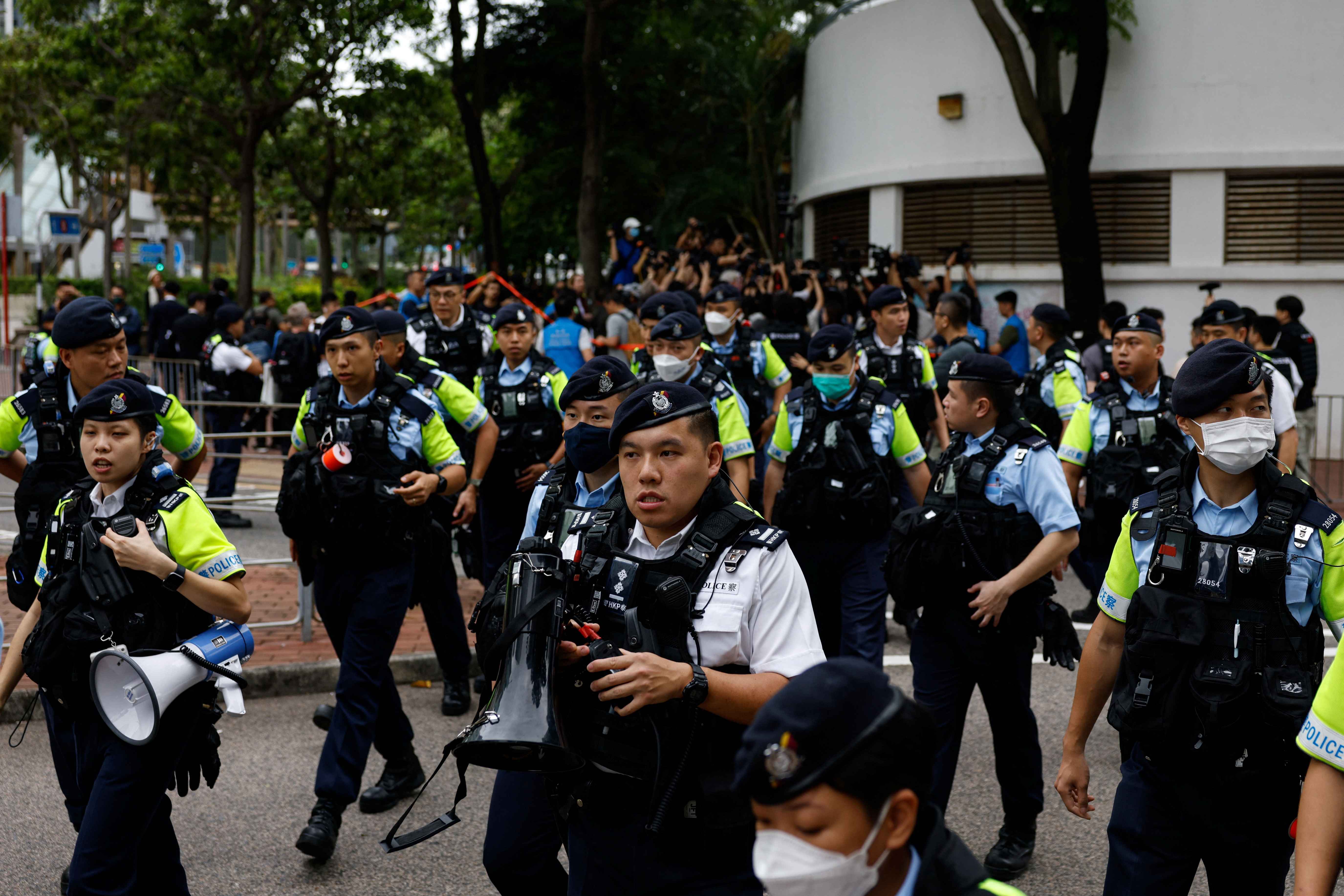 Police stand guard outside the West Kowloon Magistrates' Courts building during the verdict of the 47 pro-democracy activists charged under the national security law, in Hong Kong