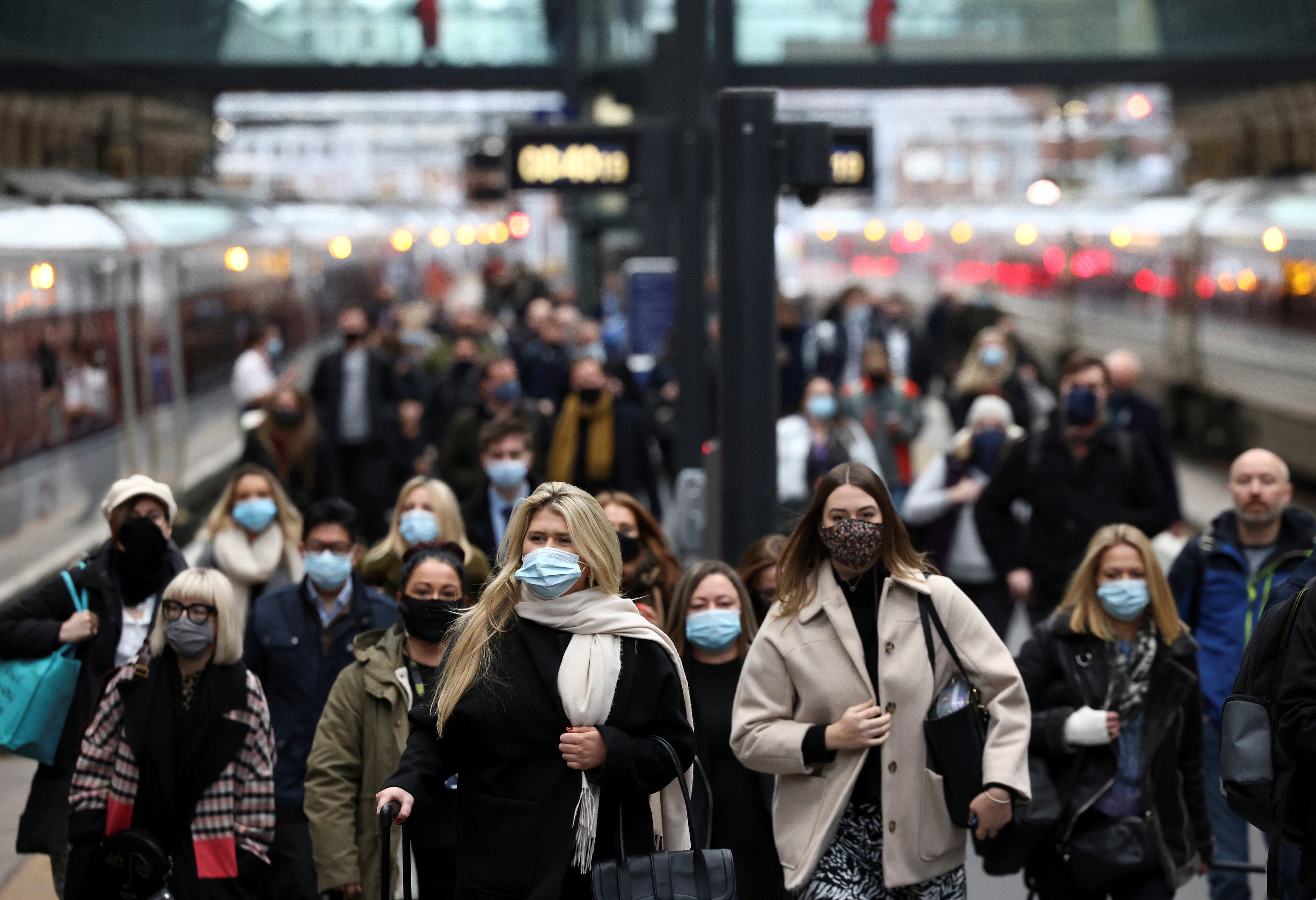 People walk along a platform at Kings Cross train station during morning rush hour, amid the coronavirus disease (COVID-19) outbreak in London, Britain, December 1, 2021. REUTERS/Henry Nicholls