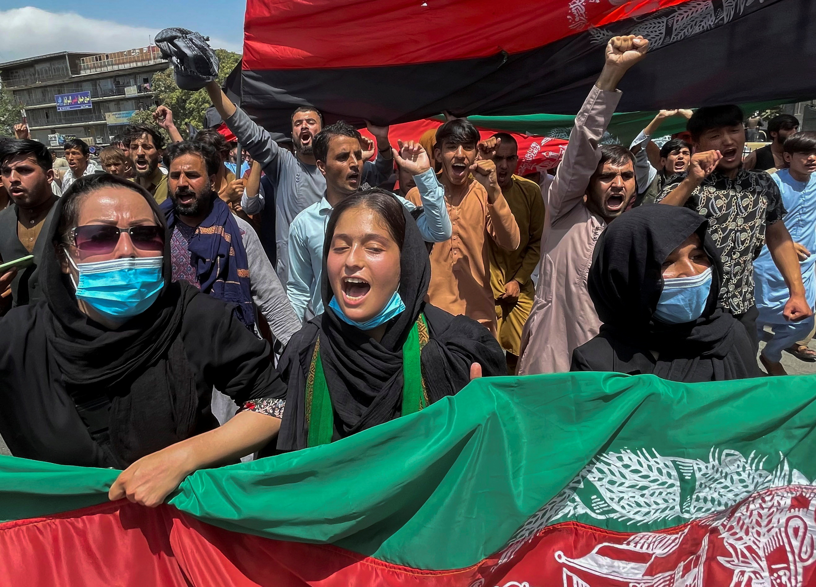 People carry the national flag at a protest held during the Afghan Independence Day in Kabul