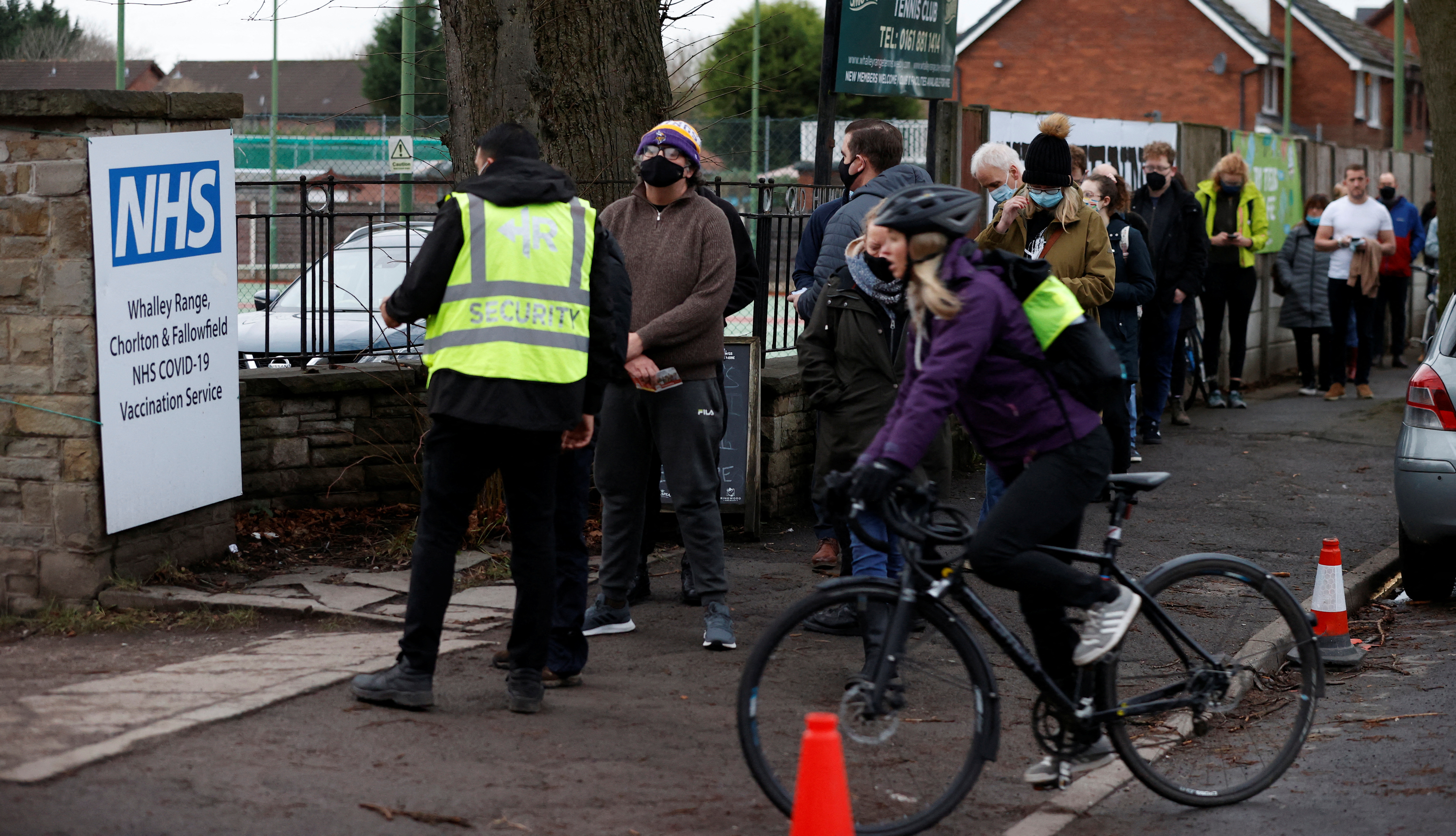 People queue for their booster jabs outside a coronavirus disease (COVID-19) vaccination centre in Manchester, Britain, December 13, 2021. REUTERS/Phil Noble