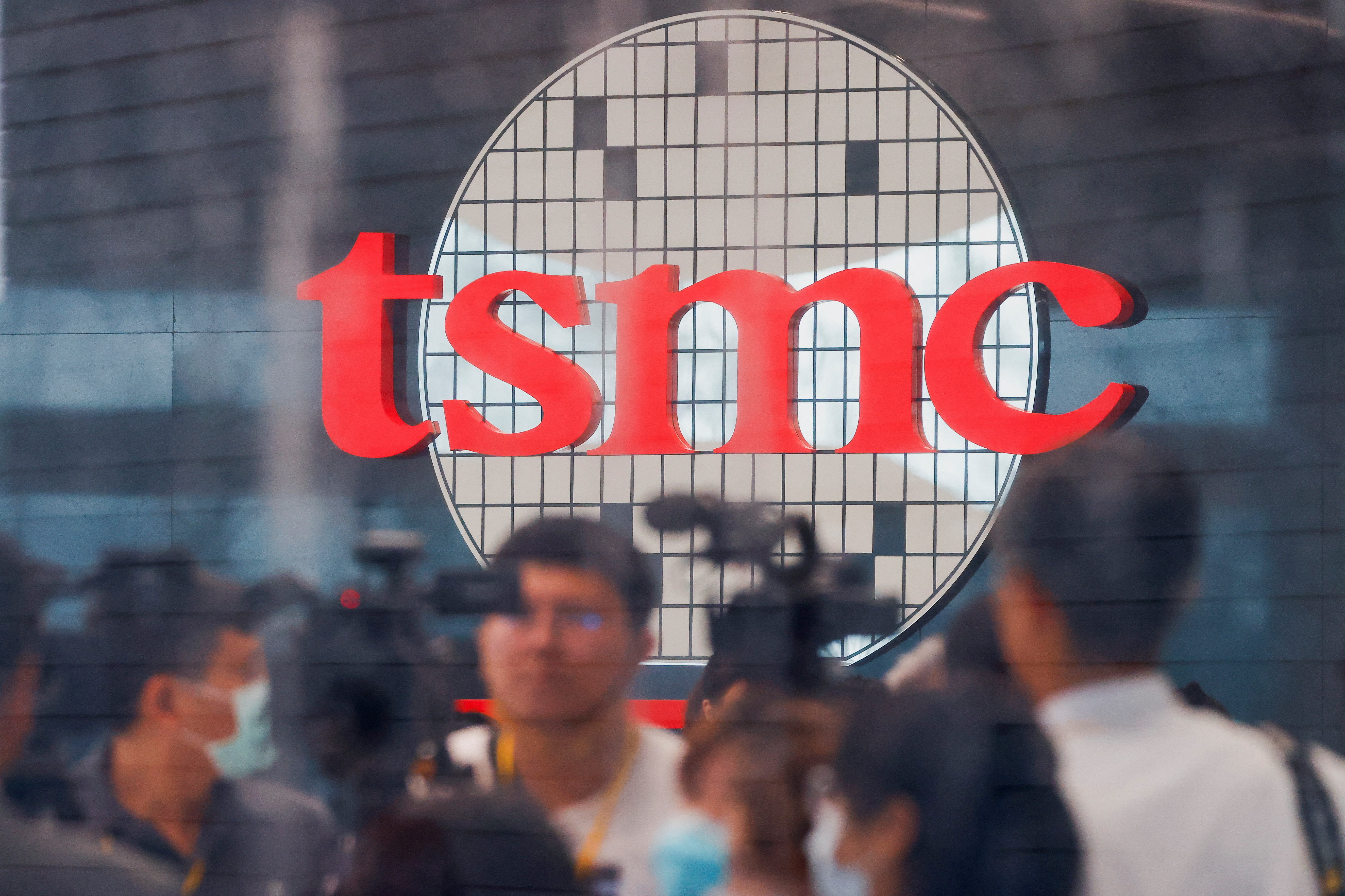 O logotipo da Taiwan Semiconductor Manufacturing Company (TSMC) é visto enquanto as pessoas participam da cerimônia de abertura do Centro Global de P&D da TSMC em Hsinchu.