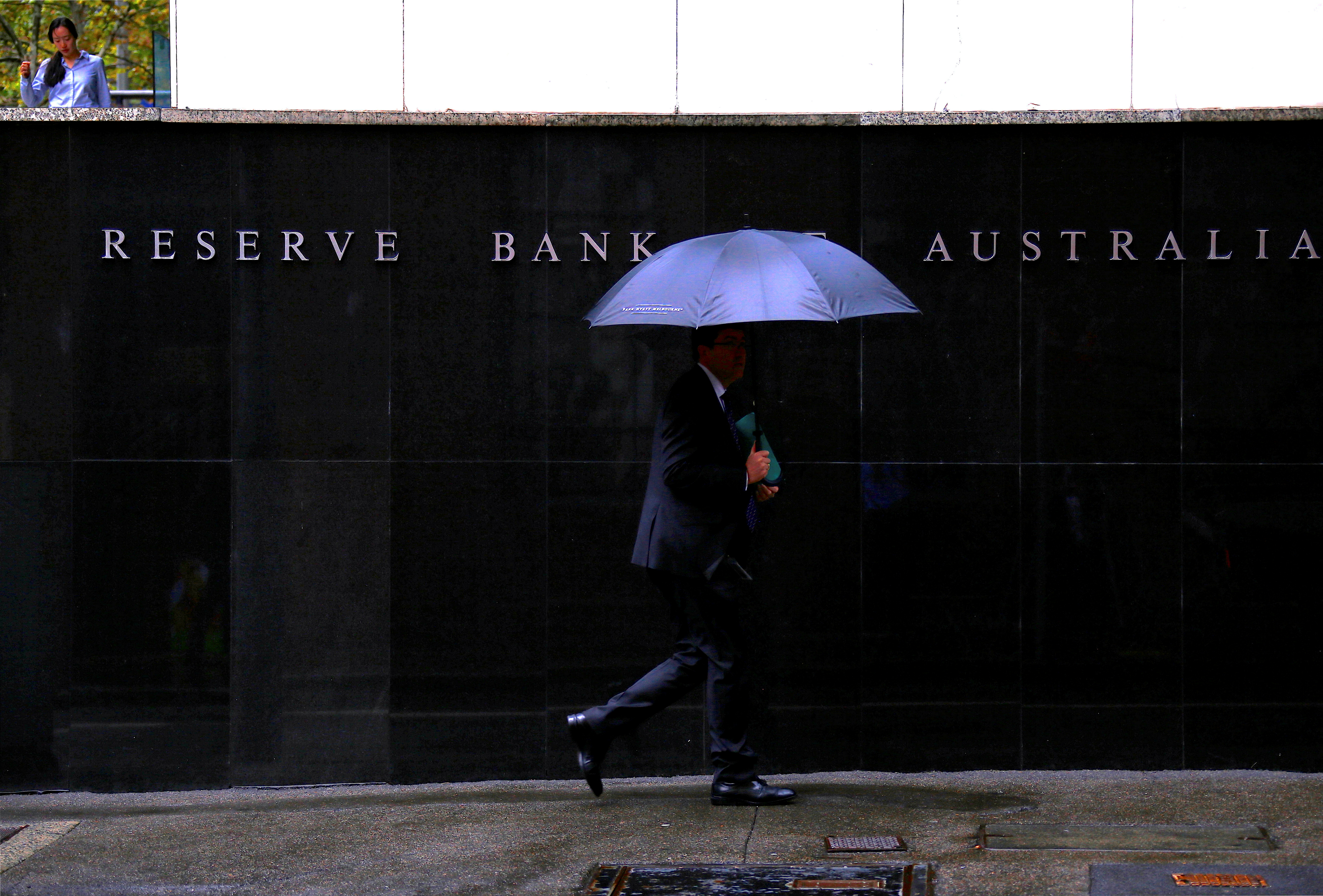 Pedestrians walk past the Reserve Bank of Australia building in central Sydney, Australia