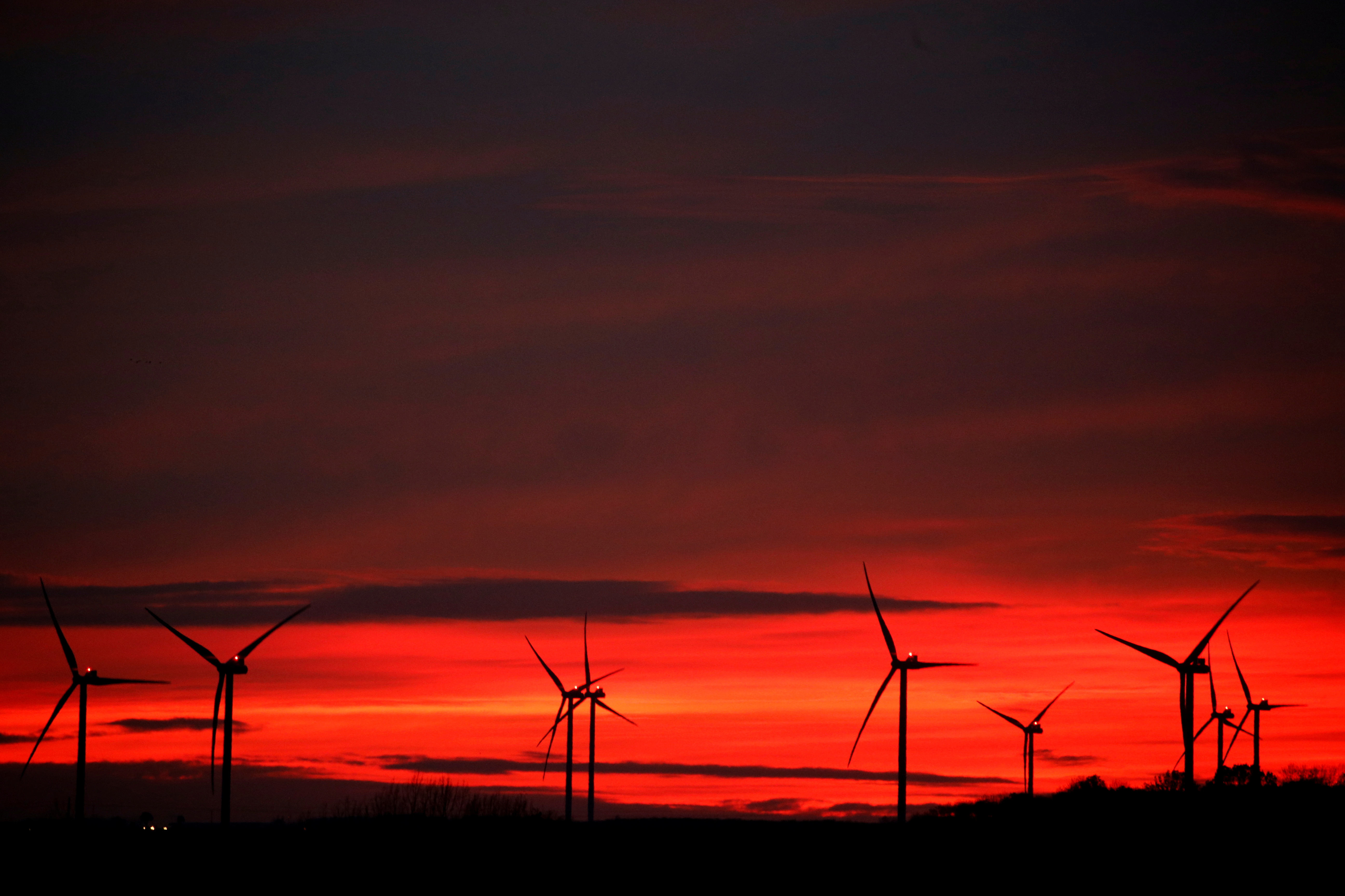 Power-generating windmill turbines are pictured at sunset at a wind park in Moeuvres near Cambrai