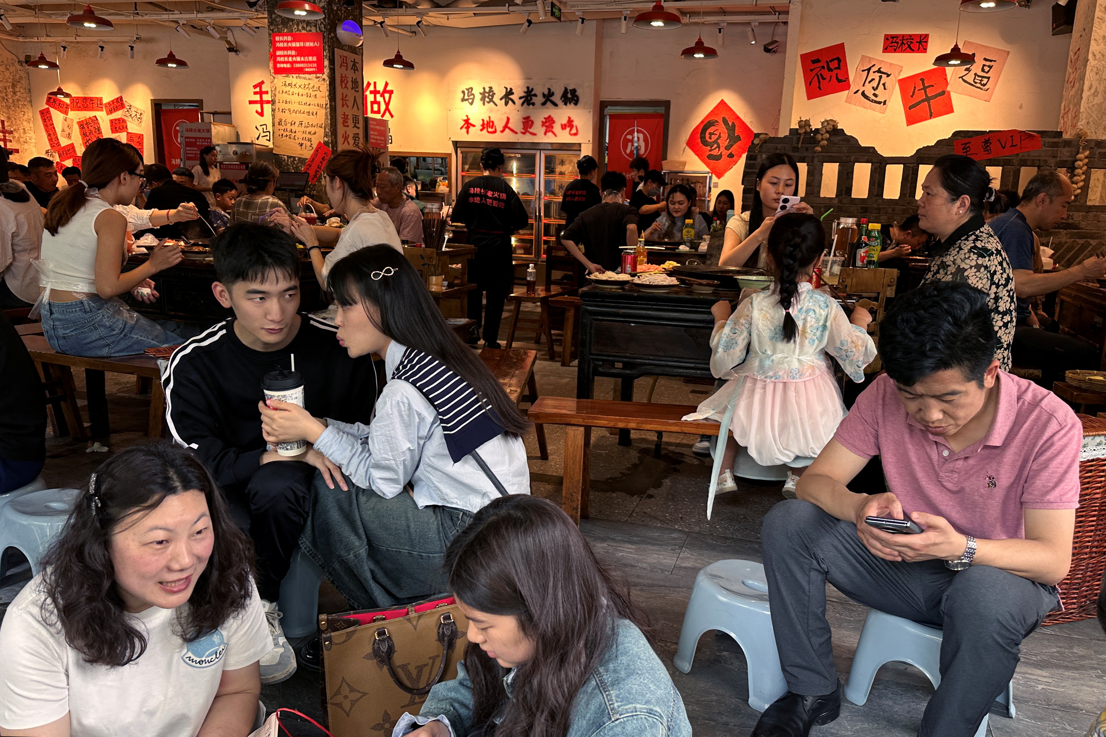 People wait for a table at a restaurant in Chengdu