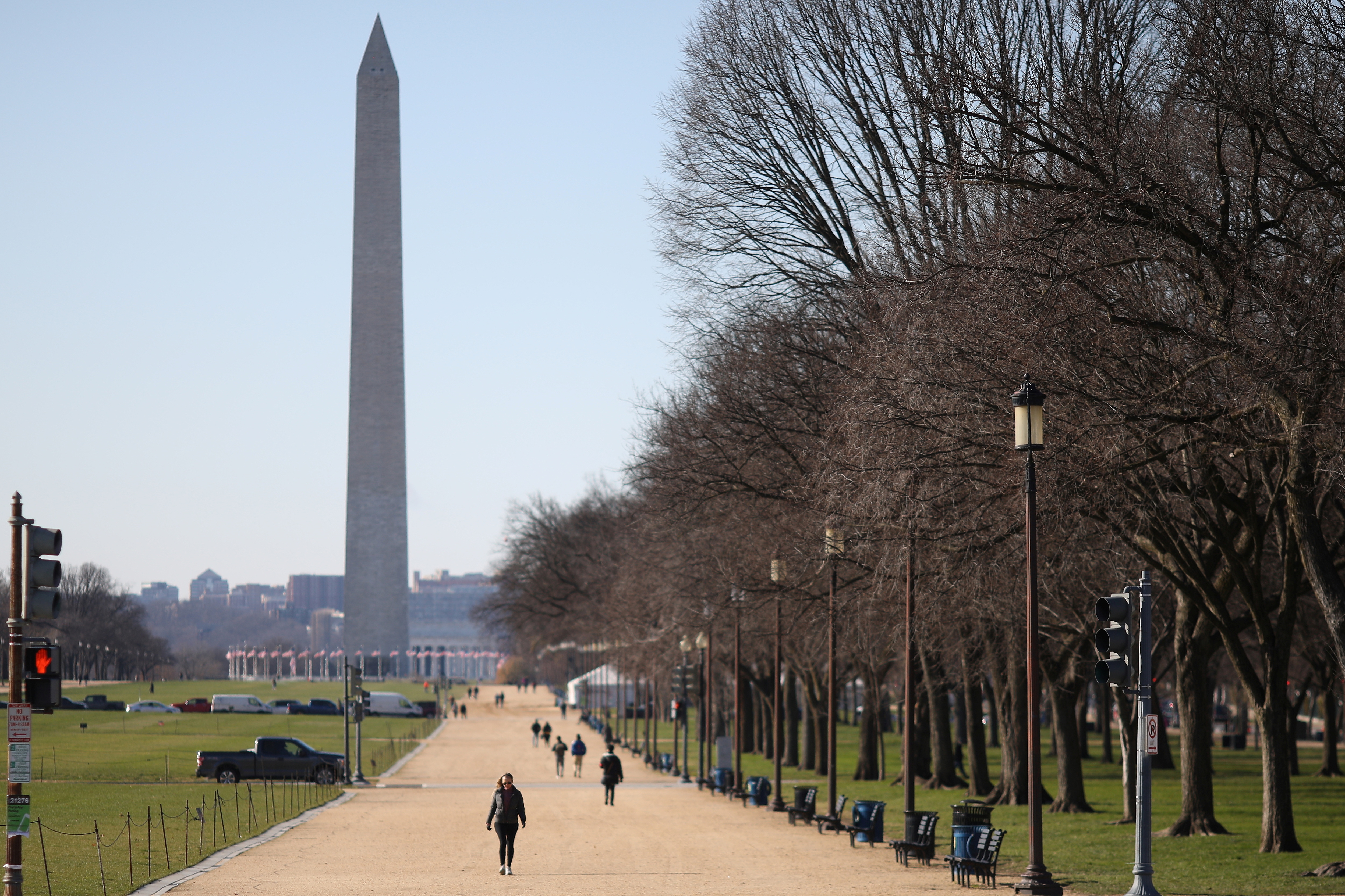 Pedestrians walk along the National Mall near the Washington Monument in Washington