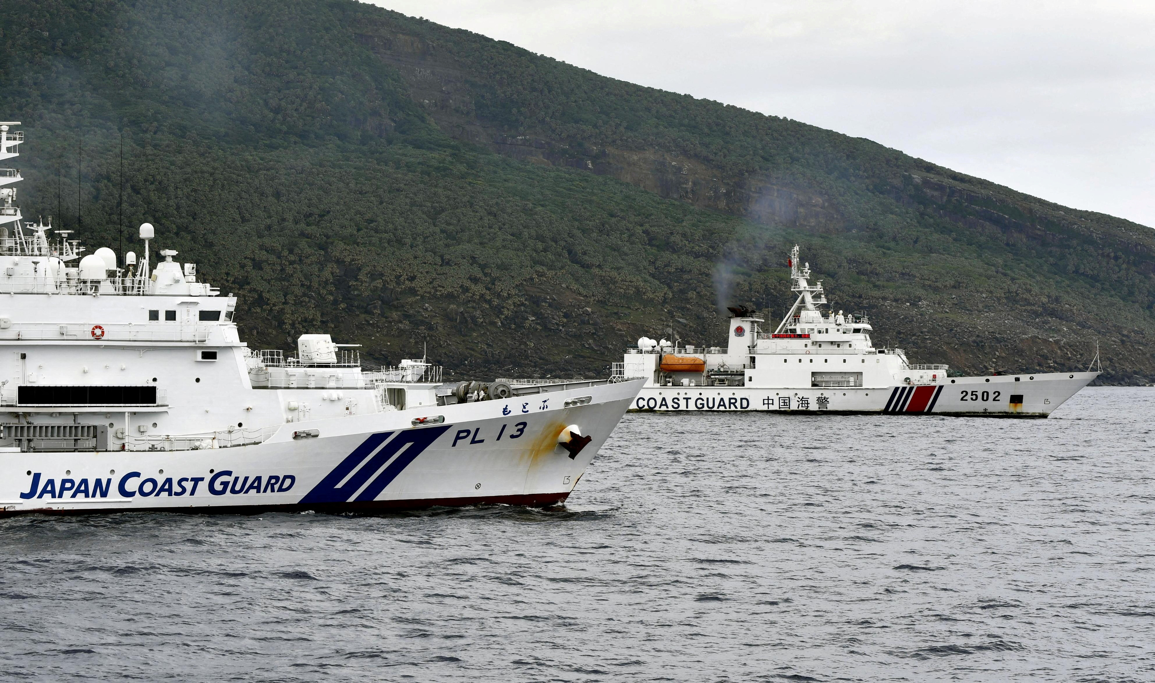 A China Coast Guard vessel sails near a Japan Coast Guard vessel off Senkaku Islands, also called in China as Diaoyu Islands, in the East China Sea