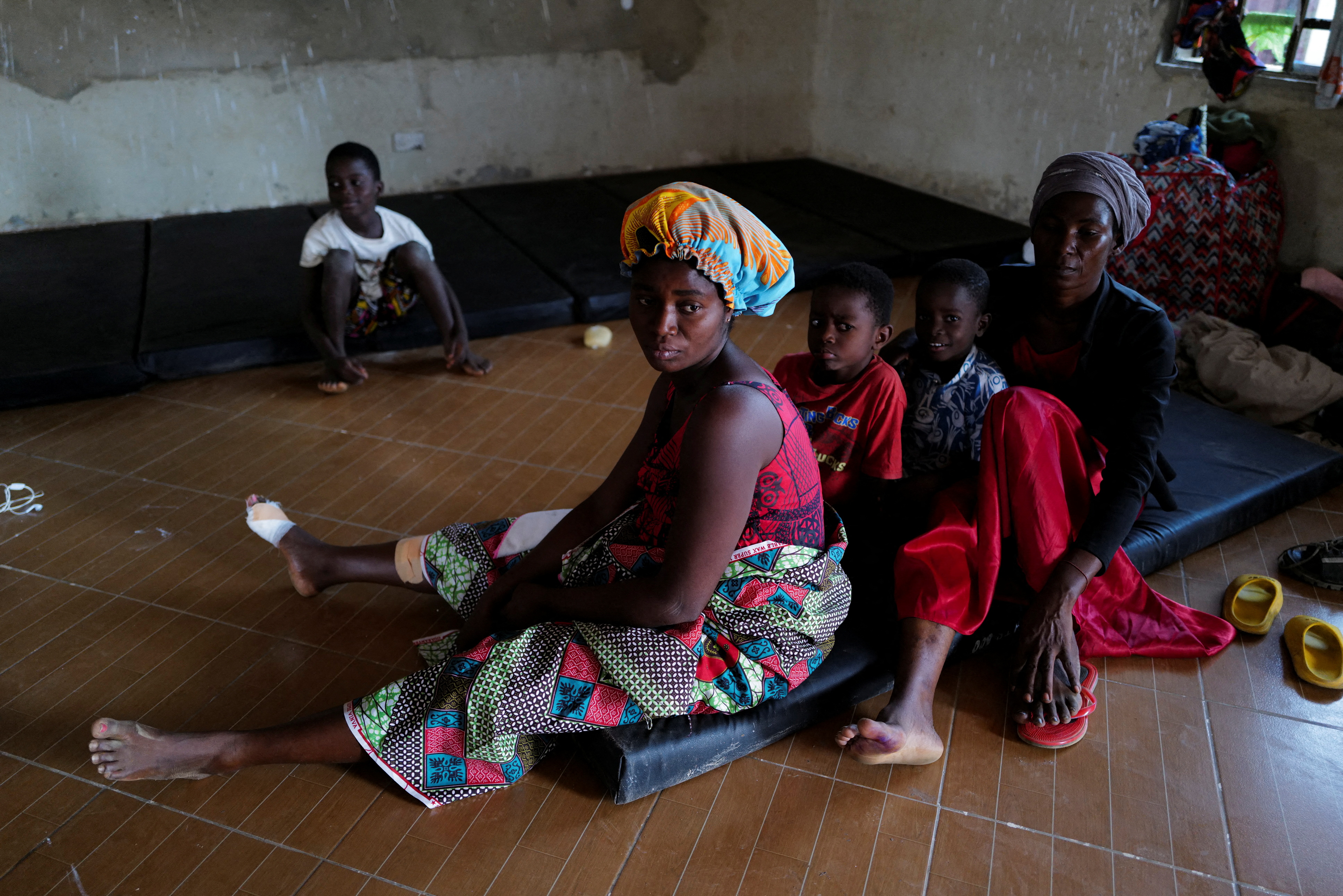Diana Essandoh, 25, whose husband died in an explosion when carrying mining explosives detonated along a road in Apiate, sits with her children and mother-in-law, at a shelter for displaced victims in Bogoso