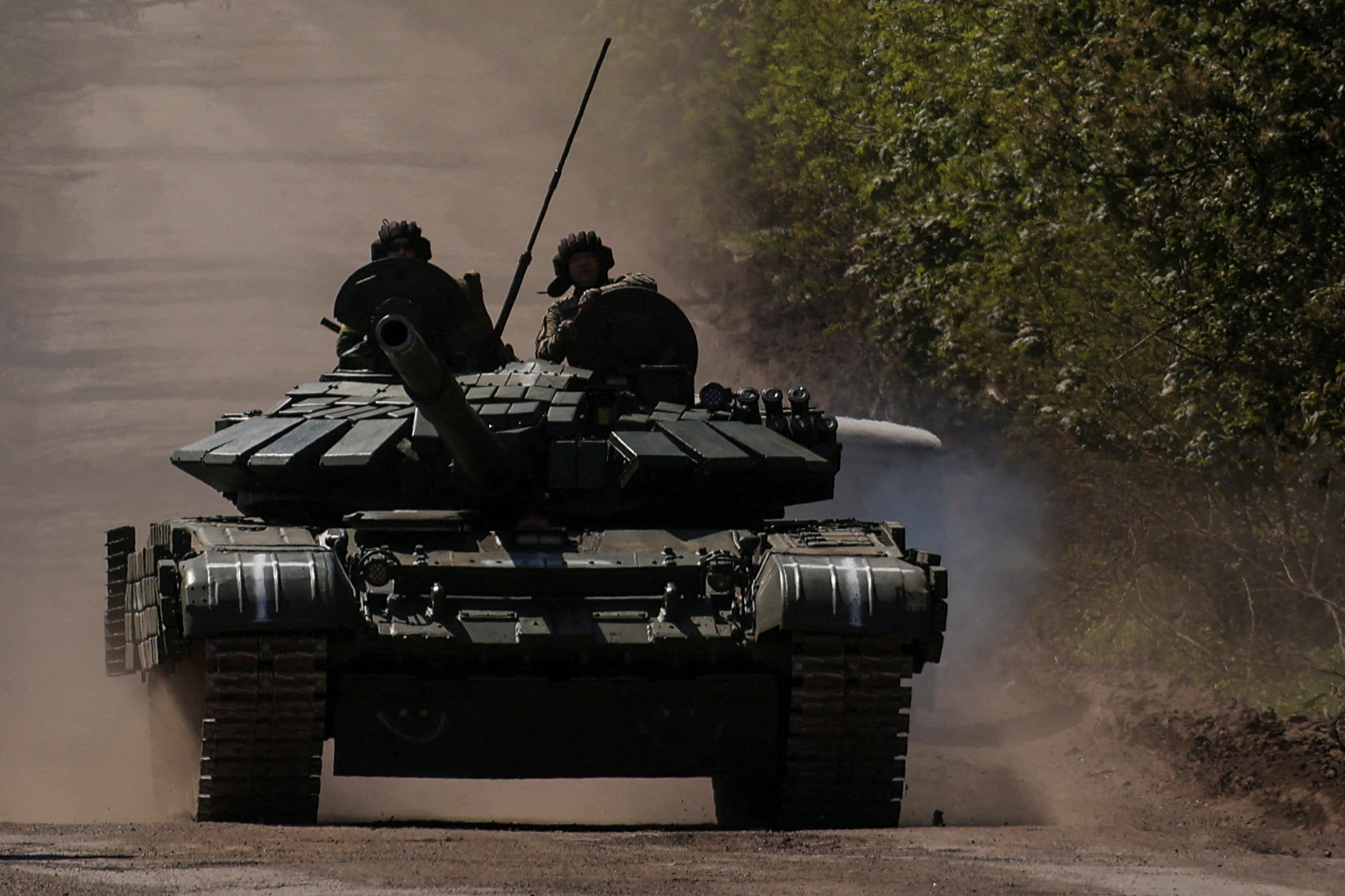 Ukrainian servicemen ride atop of a tank on a road to the frontline town of Bakhmut