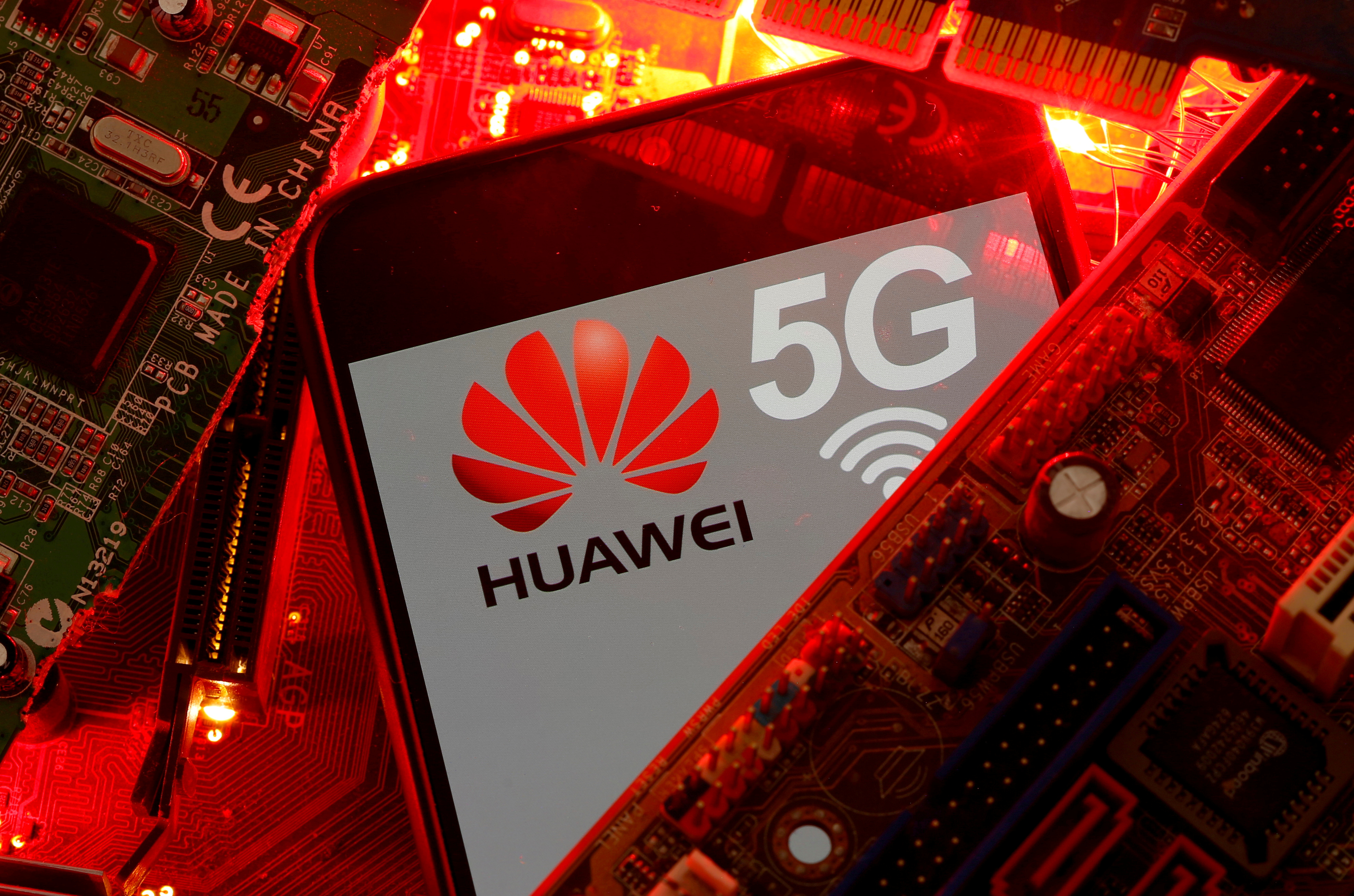 A smartphone with the Huawei and 5G network logo is seen on a PC motherboard in this illustration