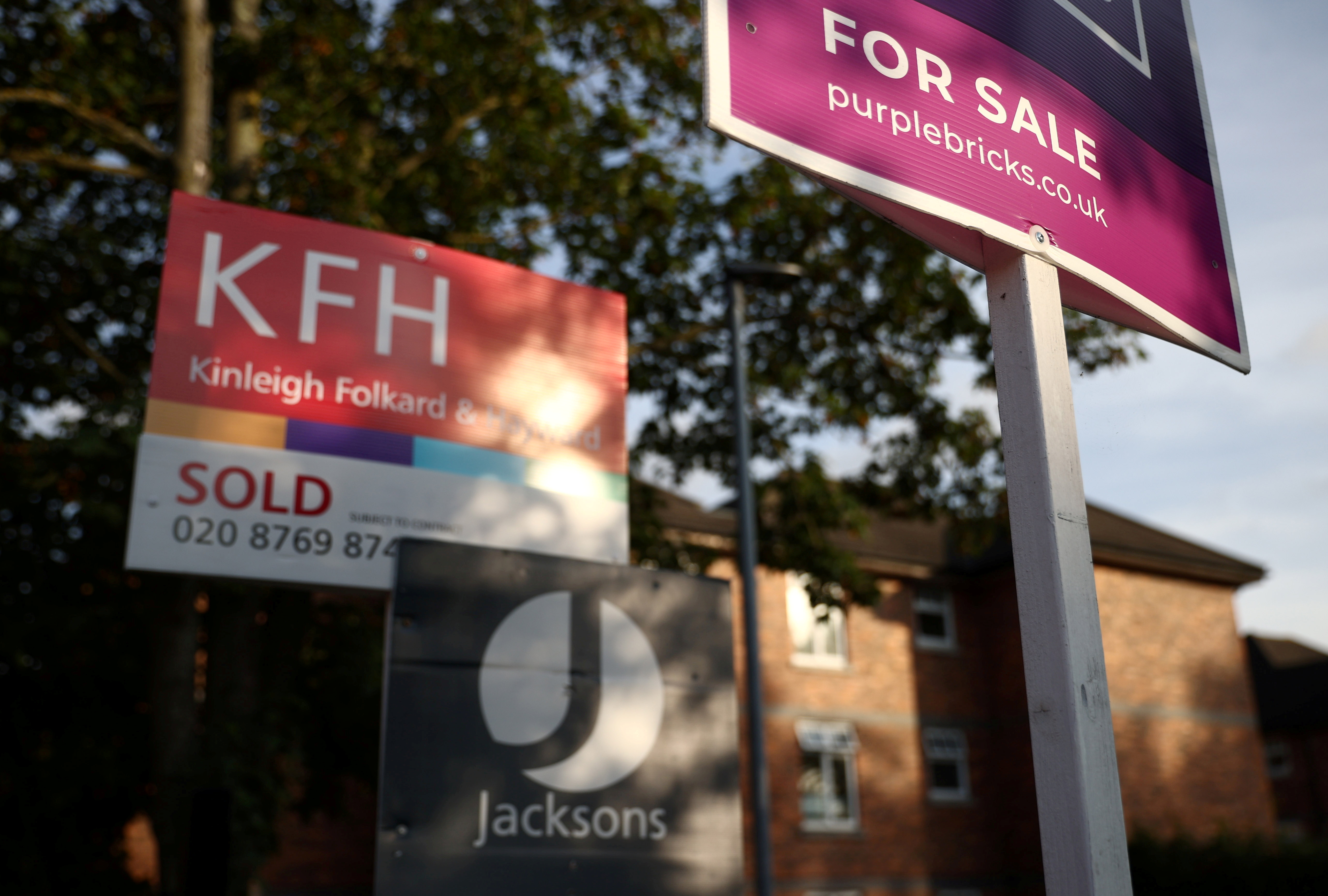 Property estate agent sales and letting signs are seen attached to railings outside an apartment building in south London, Britain, September 23, 2021. REUTERS/Hannah McKay/File Photo