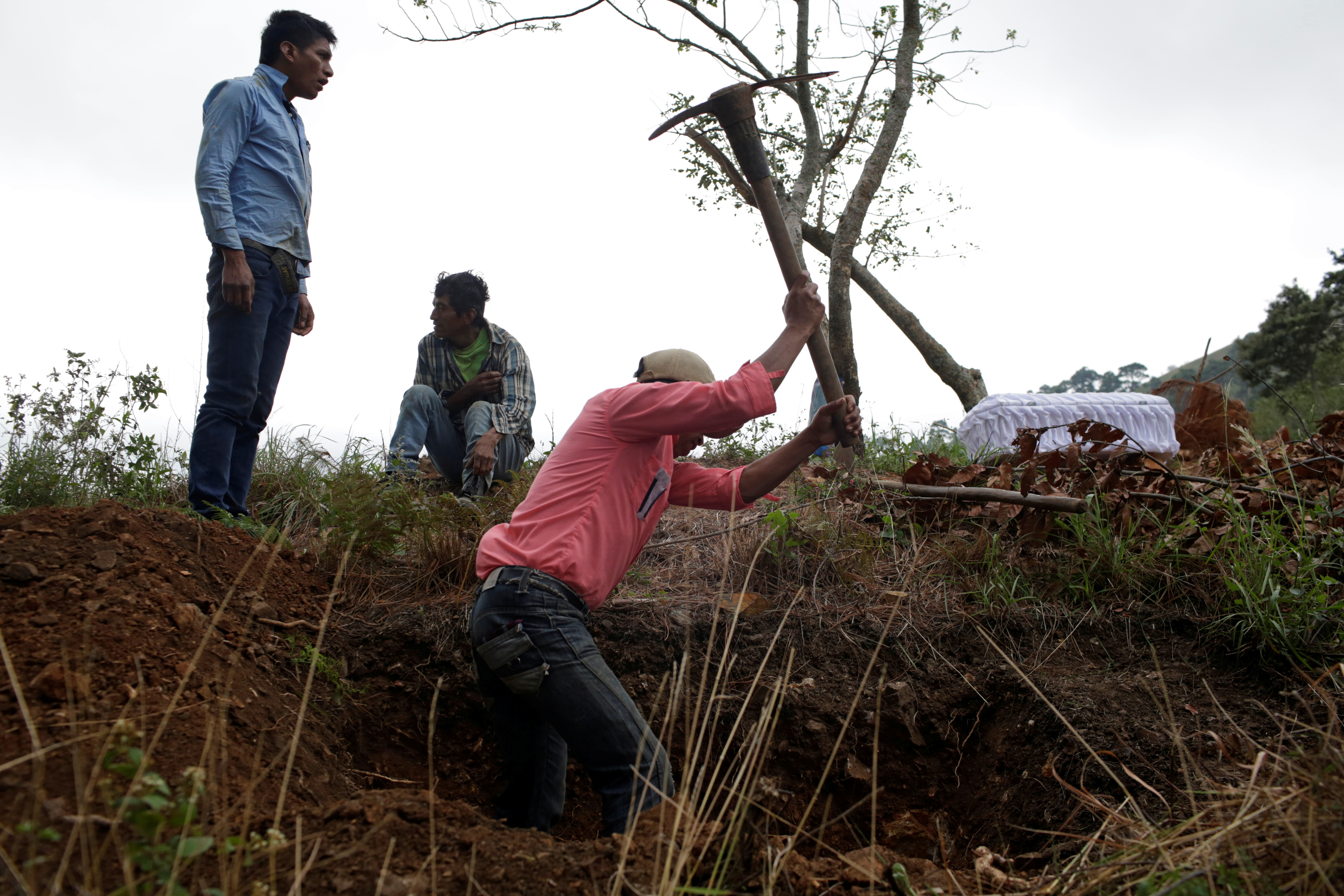 Relatives of late Yesmin Anayeli dig up a grave for her burial at a hilltop in La Palmilla