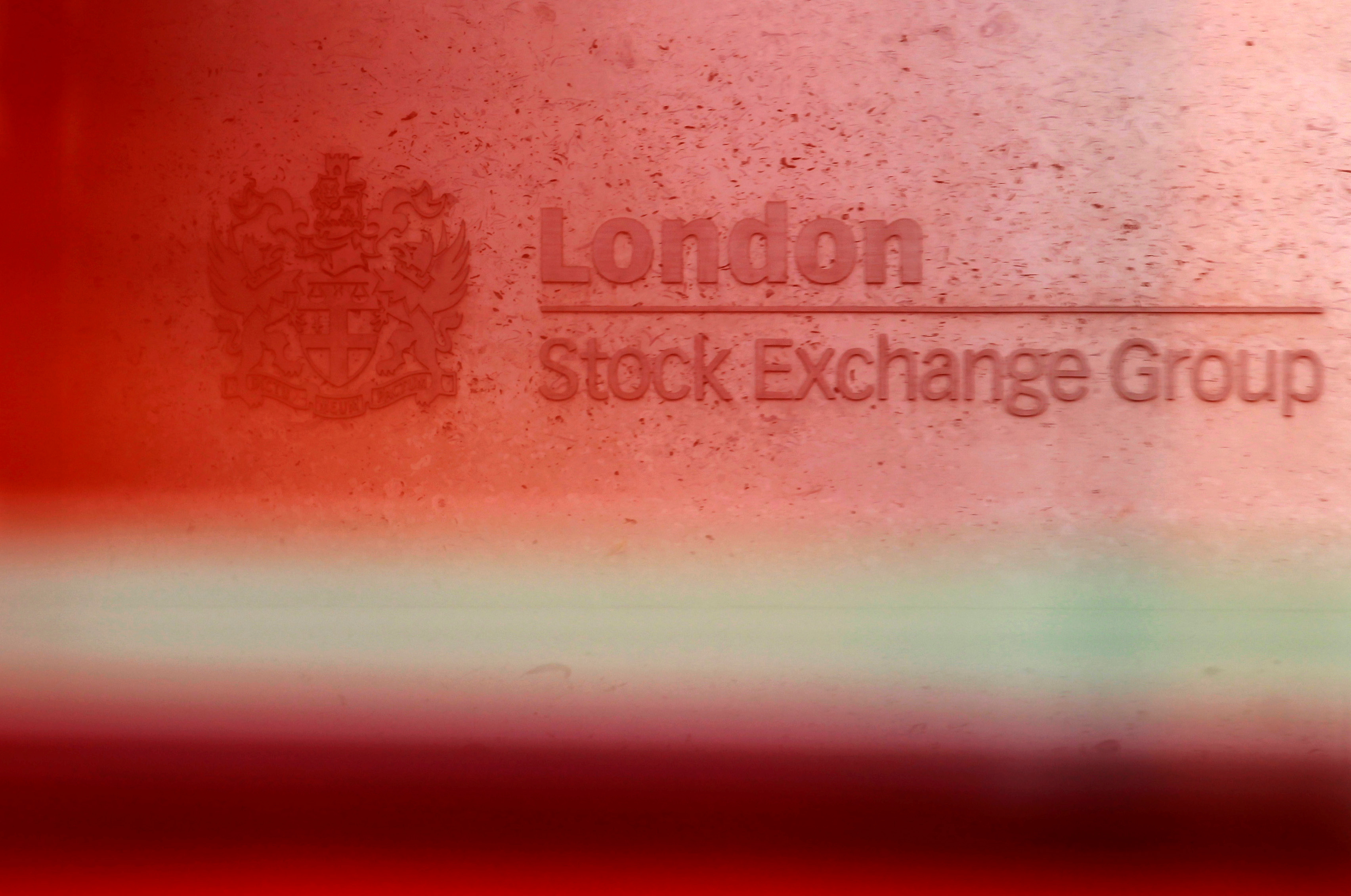 A red London bus passes the Stock Exchange in London