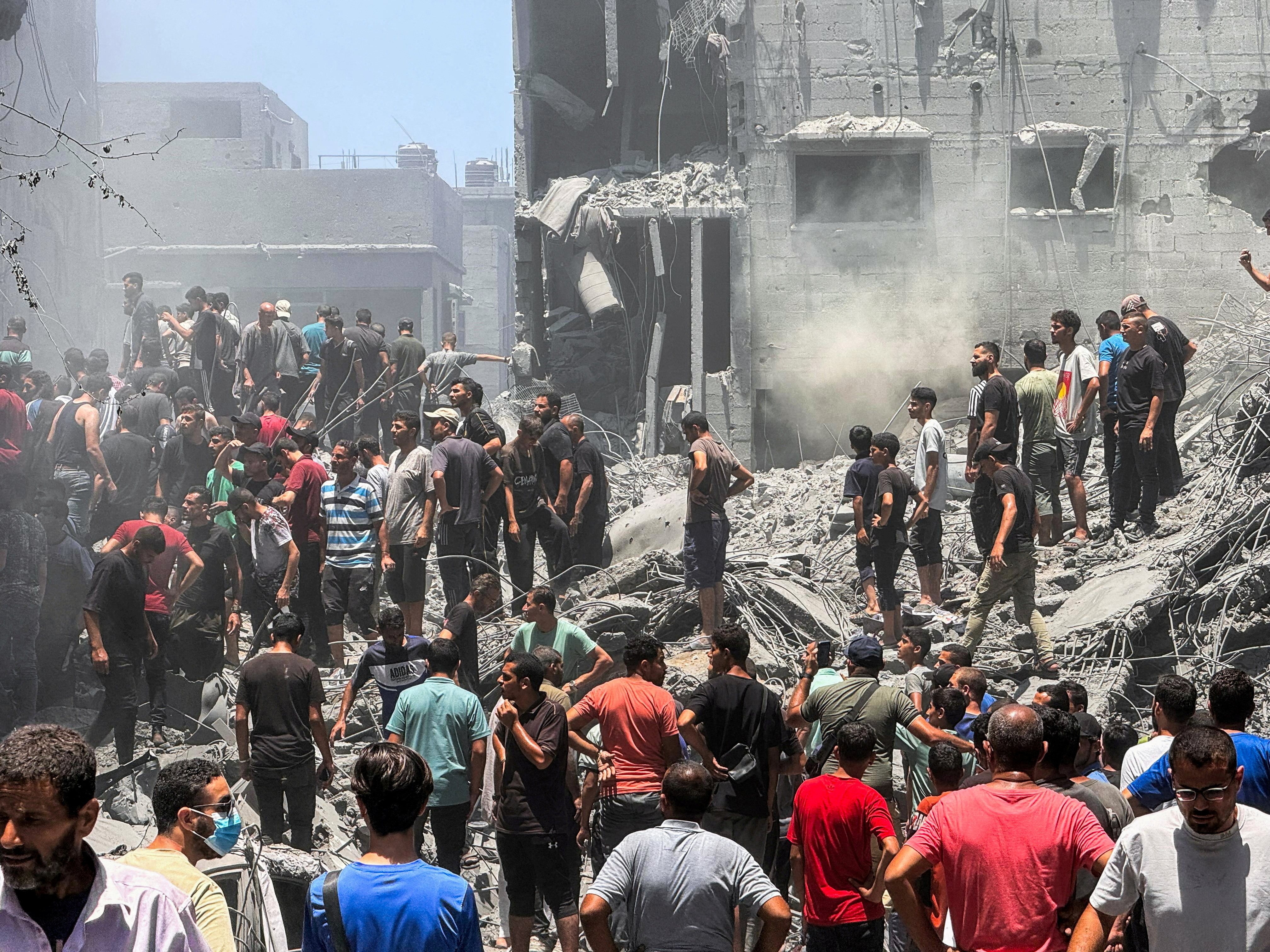 Palestinians search for casualties at the site of Israeli strikes on houses, in Gaza City