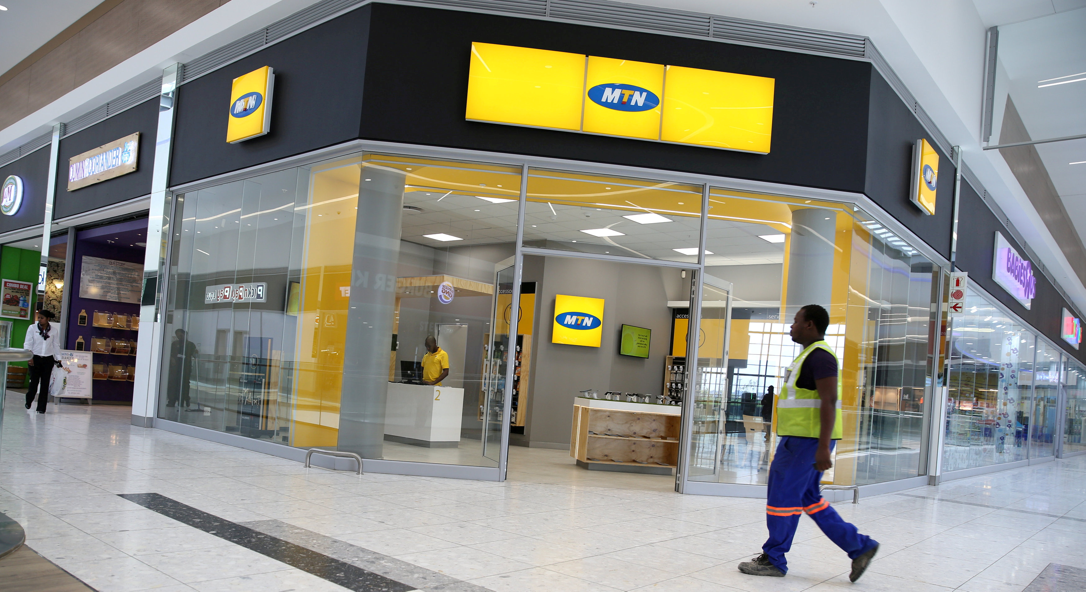 A worker walks past an outlet of South Africa's MTN Group in Johannesburg, South Africa