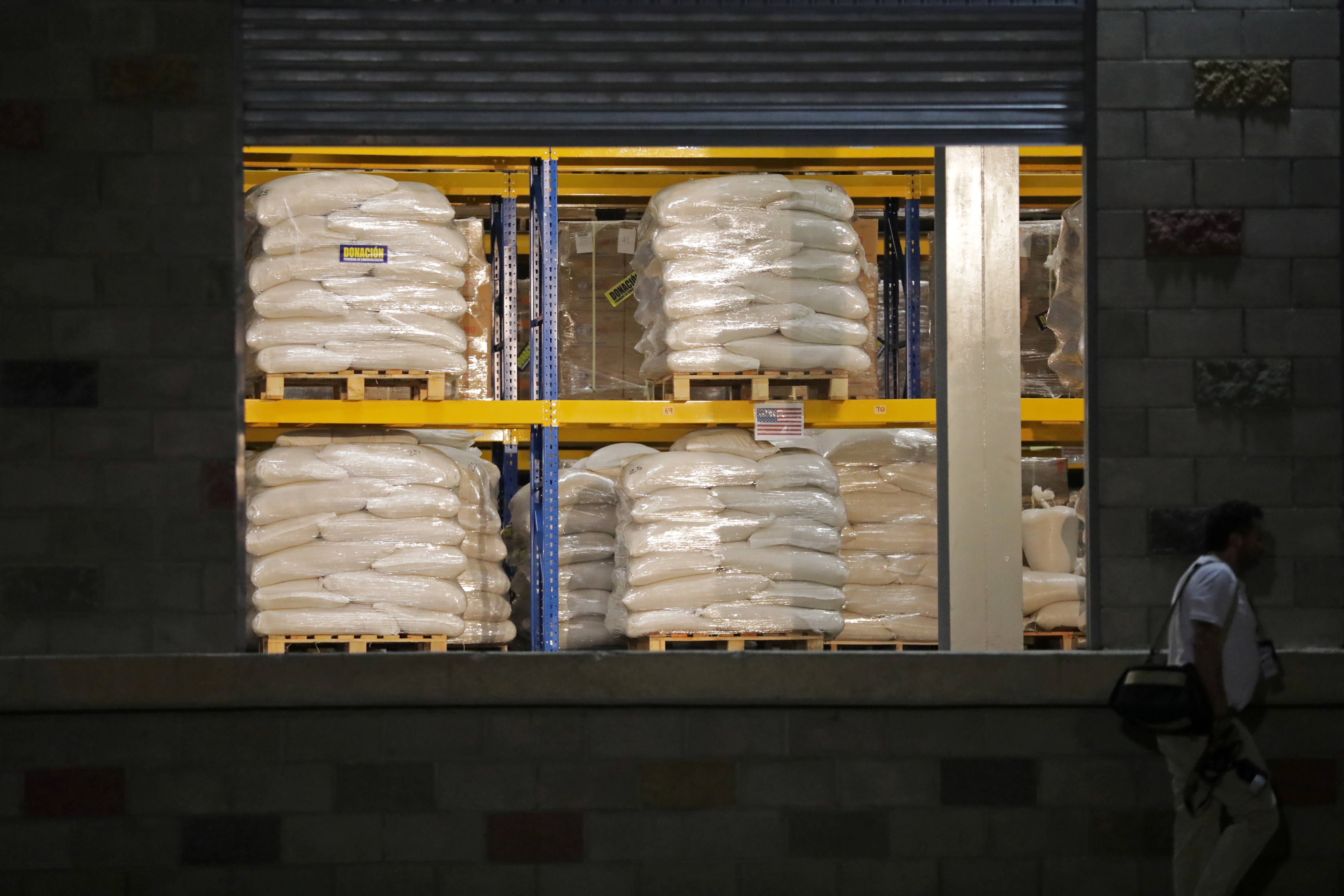 A man walks past aid at a warehouse where international humanitarian aid for Venezuela is being stored, during a visit by U.S. Secretary of State Mike Pompeo and Colombia’s President Ivan Duque, in Cucuta