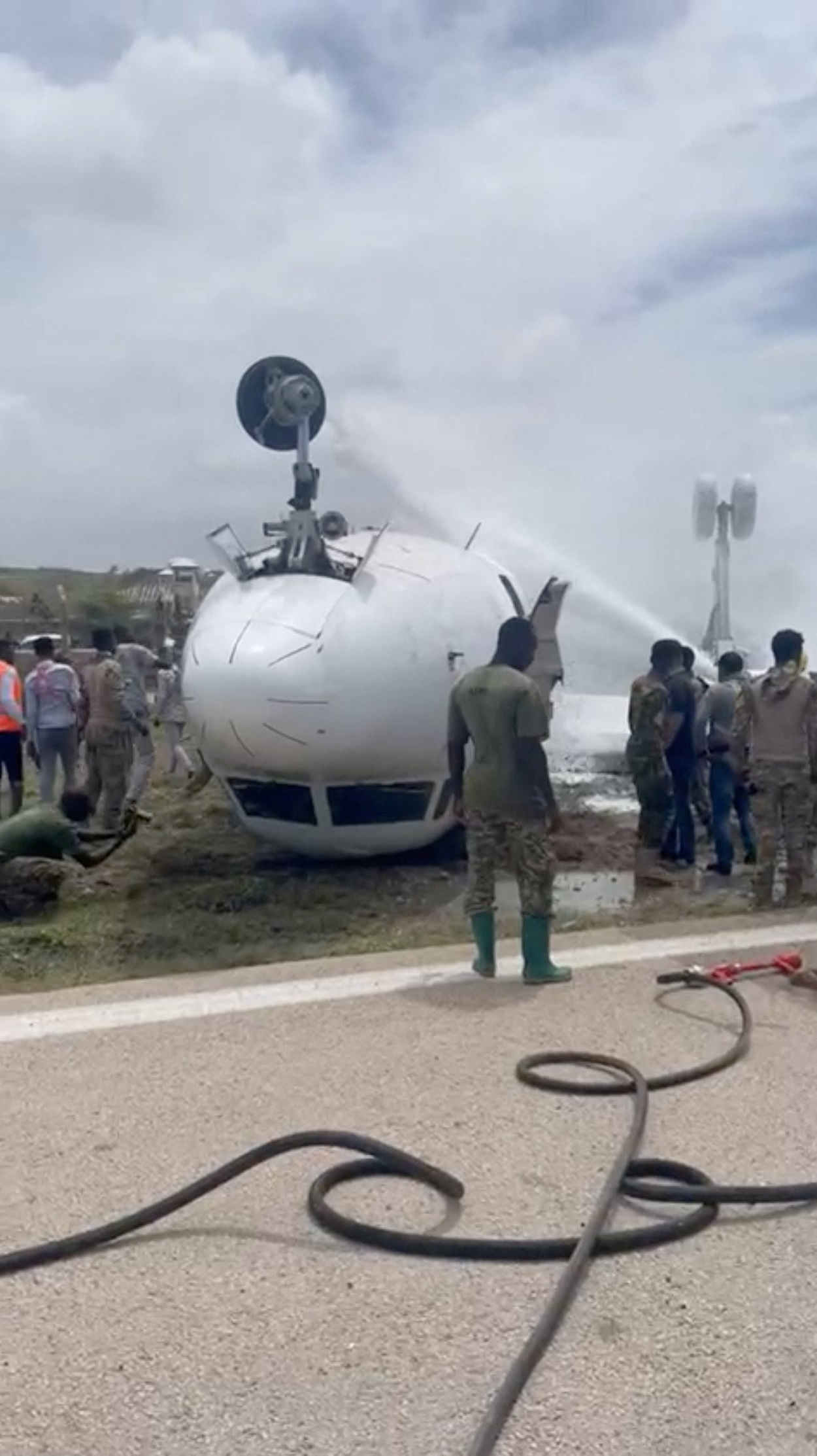 Pompierii stropesc apă pe un avion care s-a răsturnat după o aterizare accidentală, în Mogadiscio