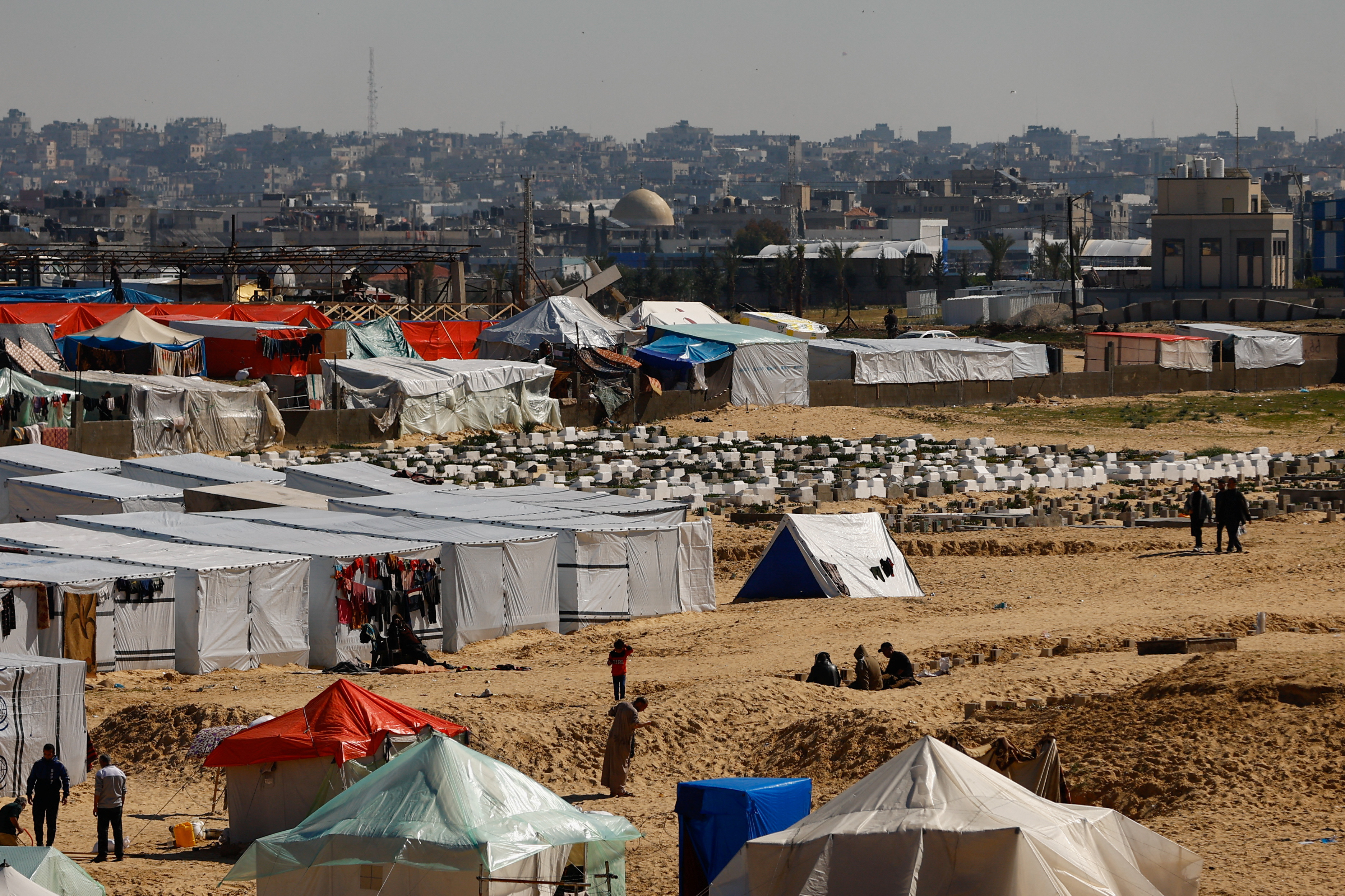 Displaced Palestinians, who fled their houses due to Israeli strikes, take shelter in a tent camp in Rafah