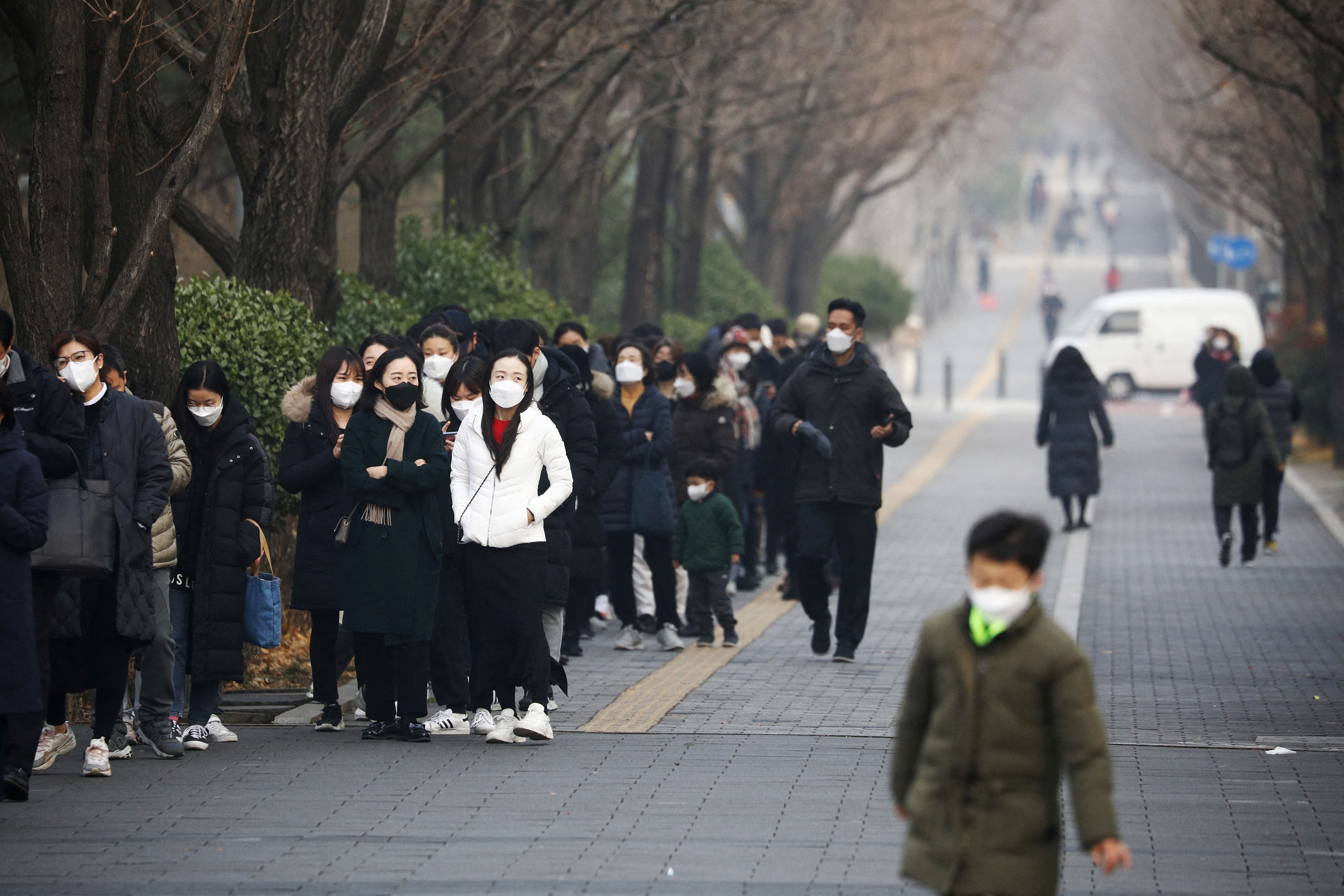 People wait in a long line to undergo coronavirus disease (COVID-19) test at a testing site in Seoul