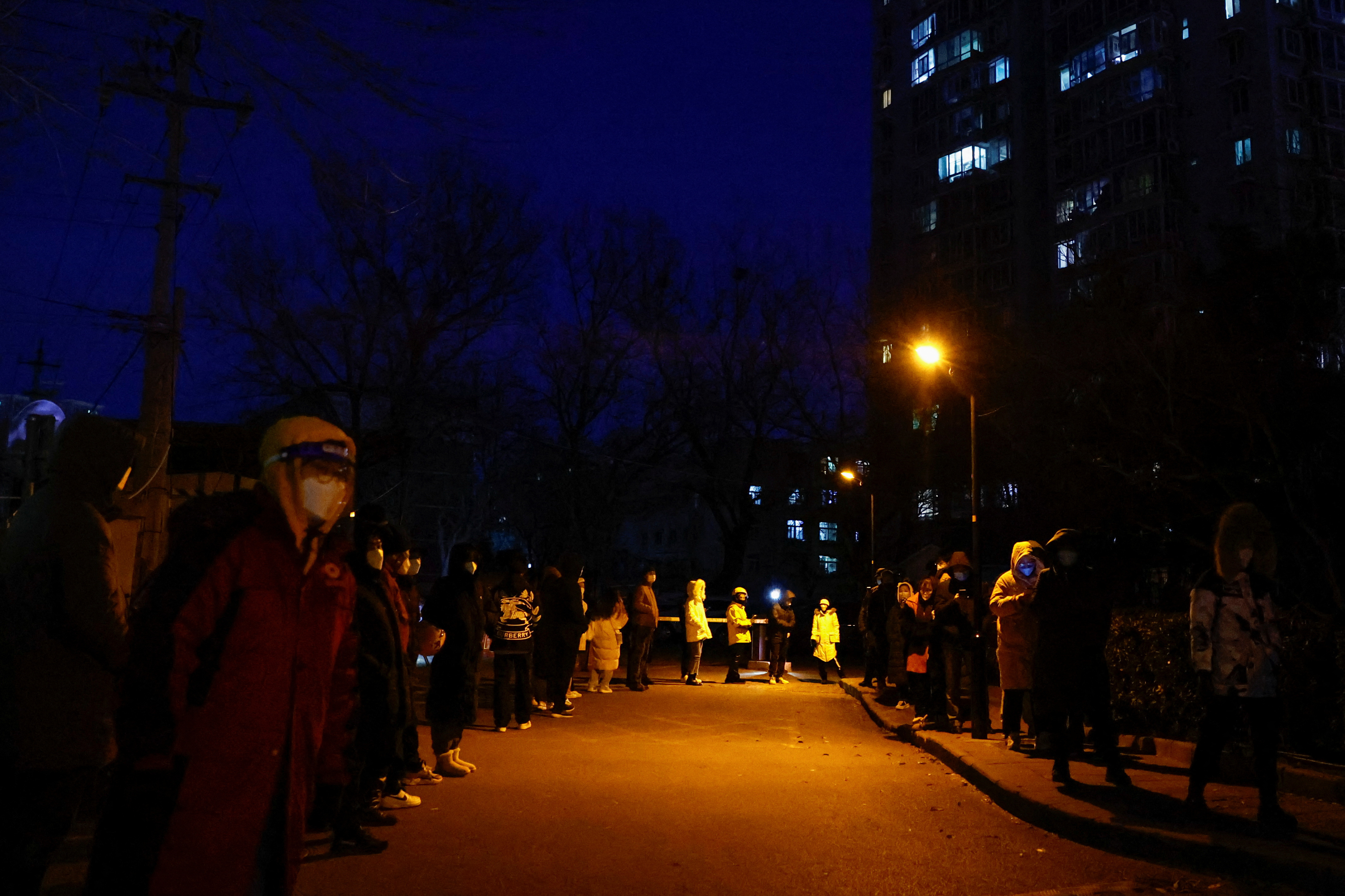 People line up to take a nucleic acid test for the coronavirus disease (COVID-19), near a residential compound in Beijing