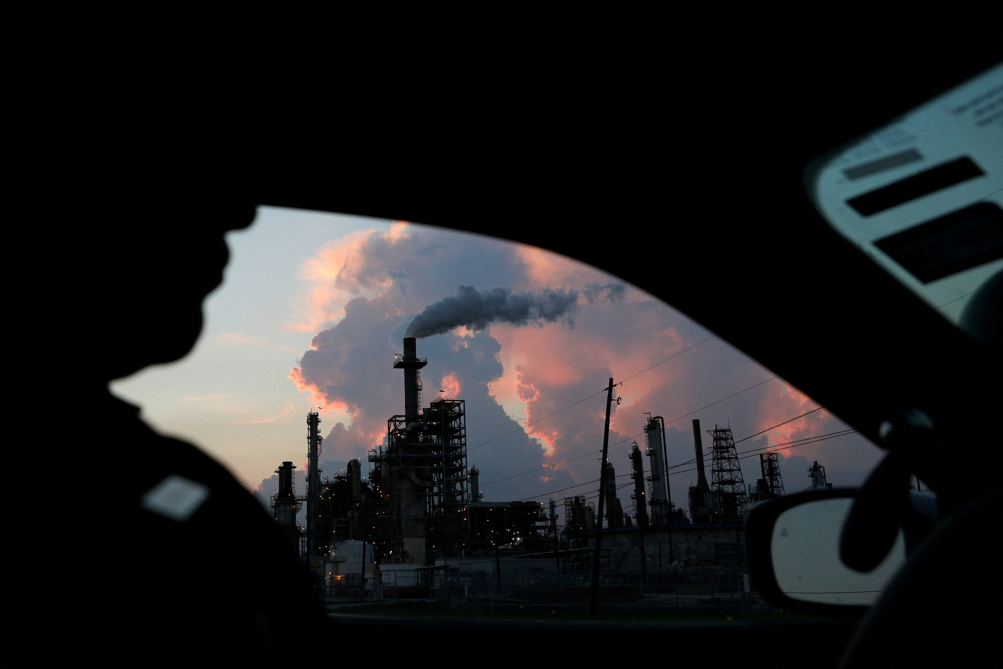 A police officer drives past a refinery in the industrial east end in Pasadena