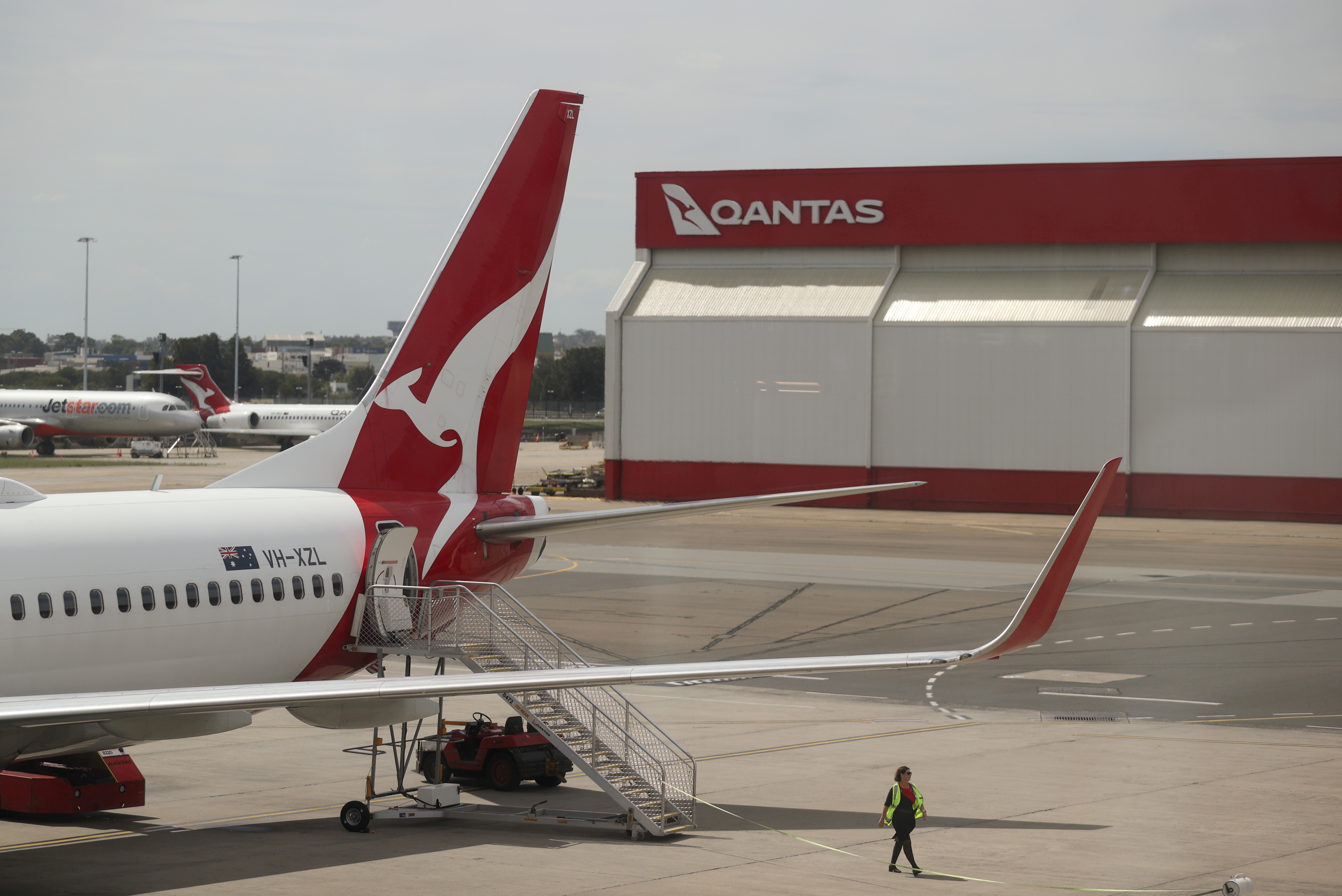 A crew member walks from a Qantas plane at a domestic terminal at Sydney Airport in Sydney