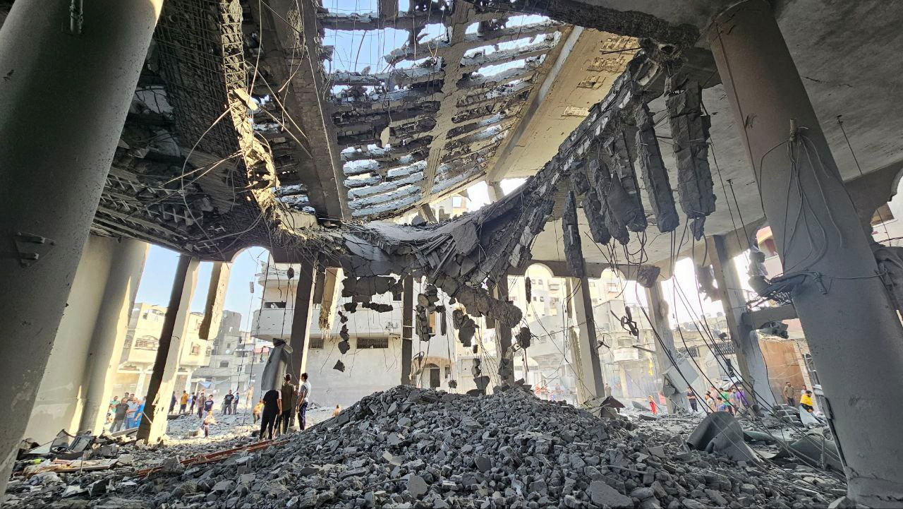 Palestinos inspecionam os restos de uma mesquita destruída em ataques israelenses, no norte da Faixa de Gaza