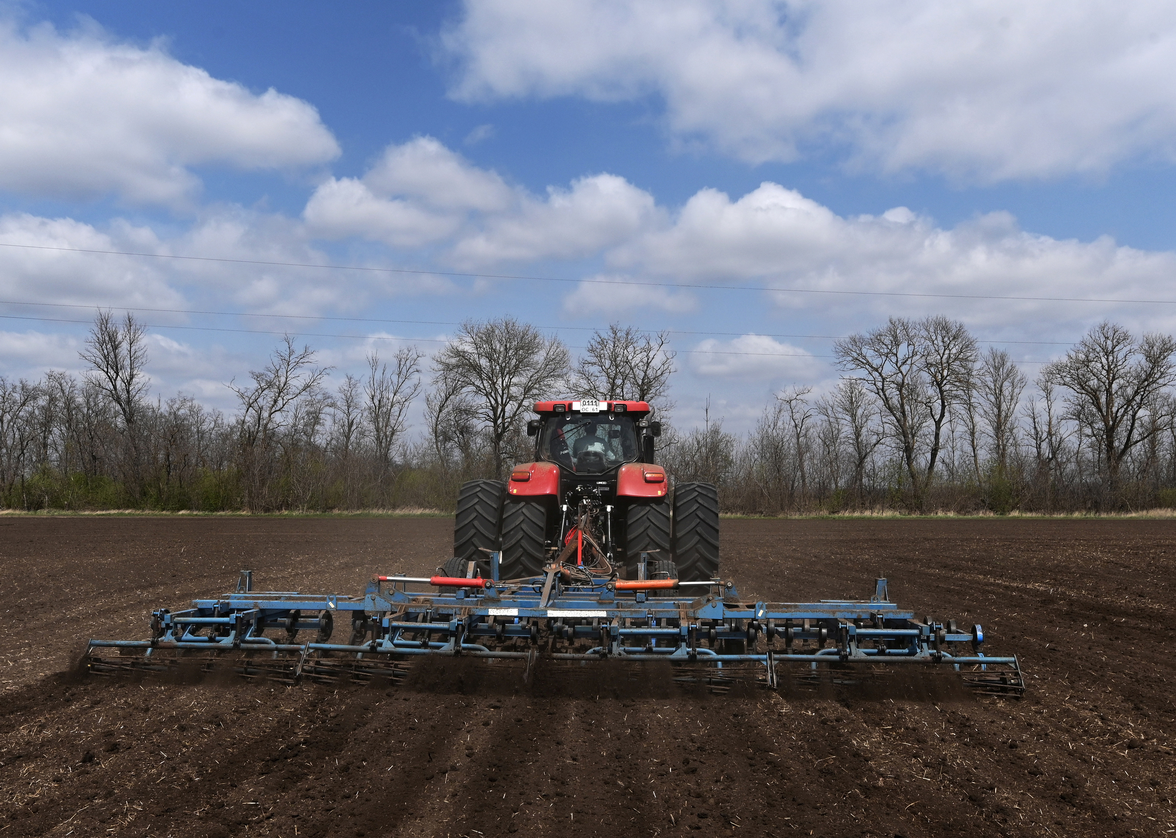 A farmer operates a tractor to prepare the land before sowing of sunflower in the field in Rostov region