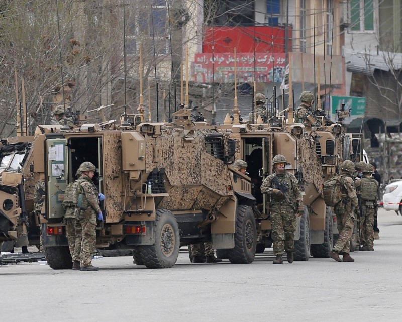 NATO soldiers inspect near the site of an attack in Kabul