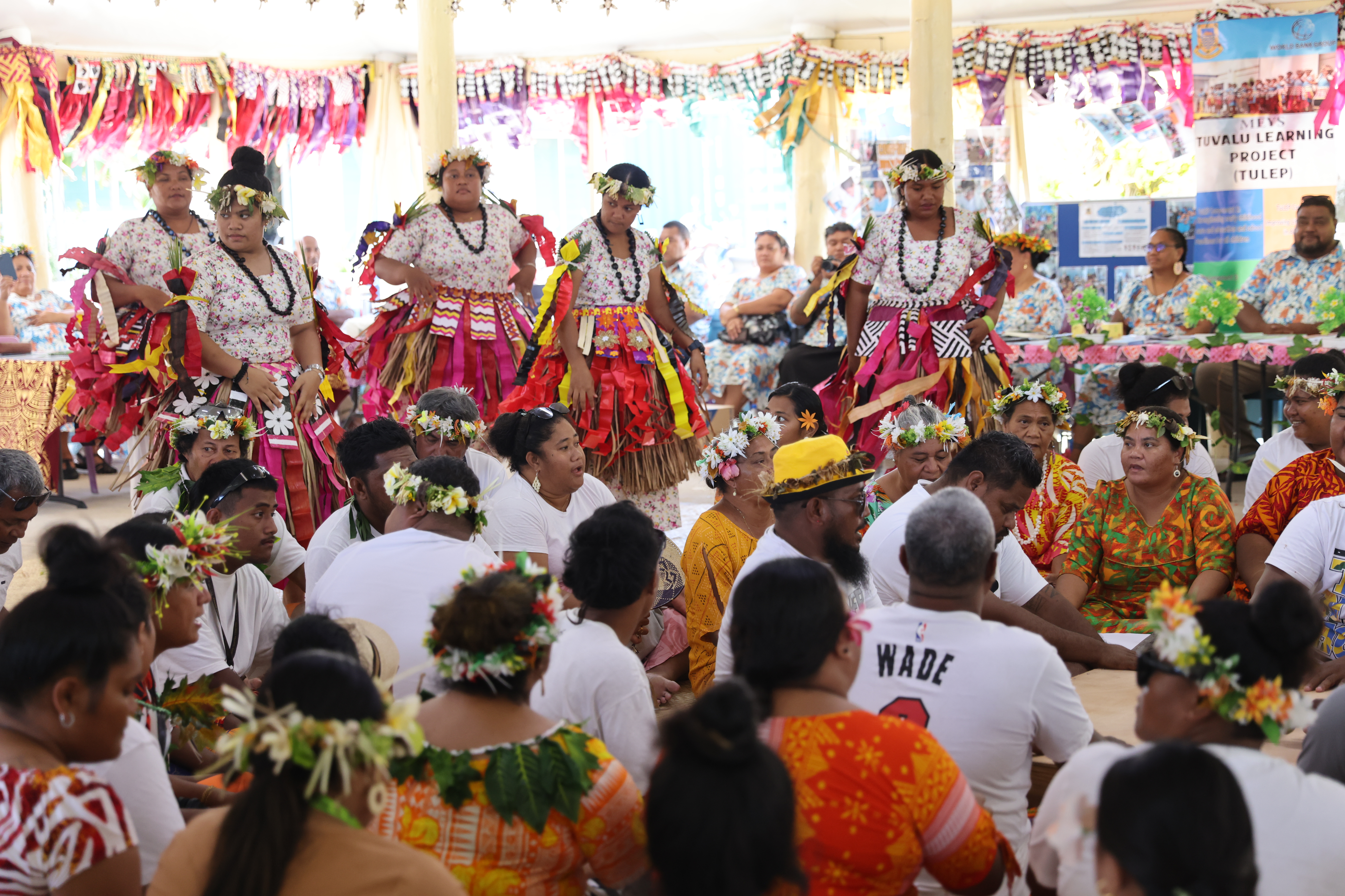 Dançarinos e cantores tradicionais realizam uma cerimônia de boas-vindas em um salão comunitário no Aeroporto de Funafuti