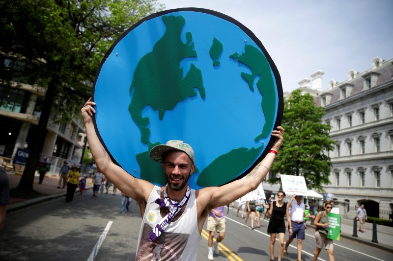 A protester carries a sign depicting the earth during the Peoples Climate March near the White House in Washington