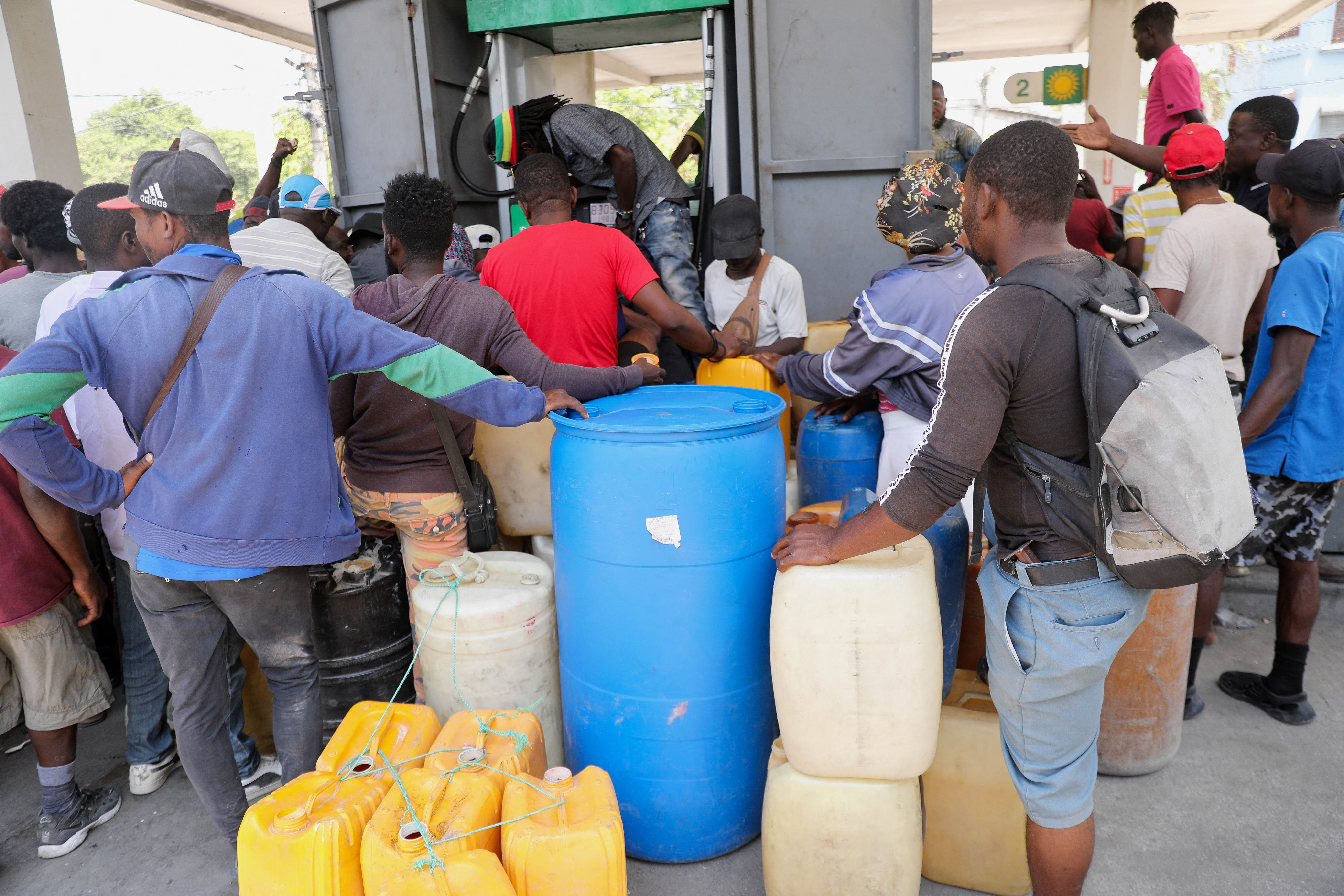 People gather to buy gasoline at a petrol station in Port-au-Prince